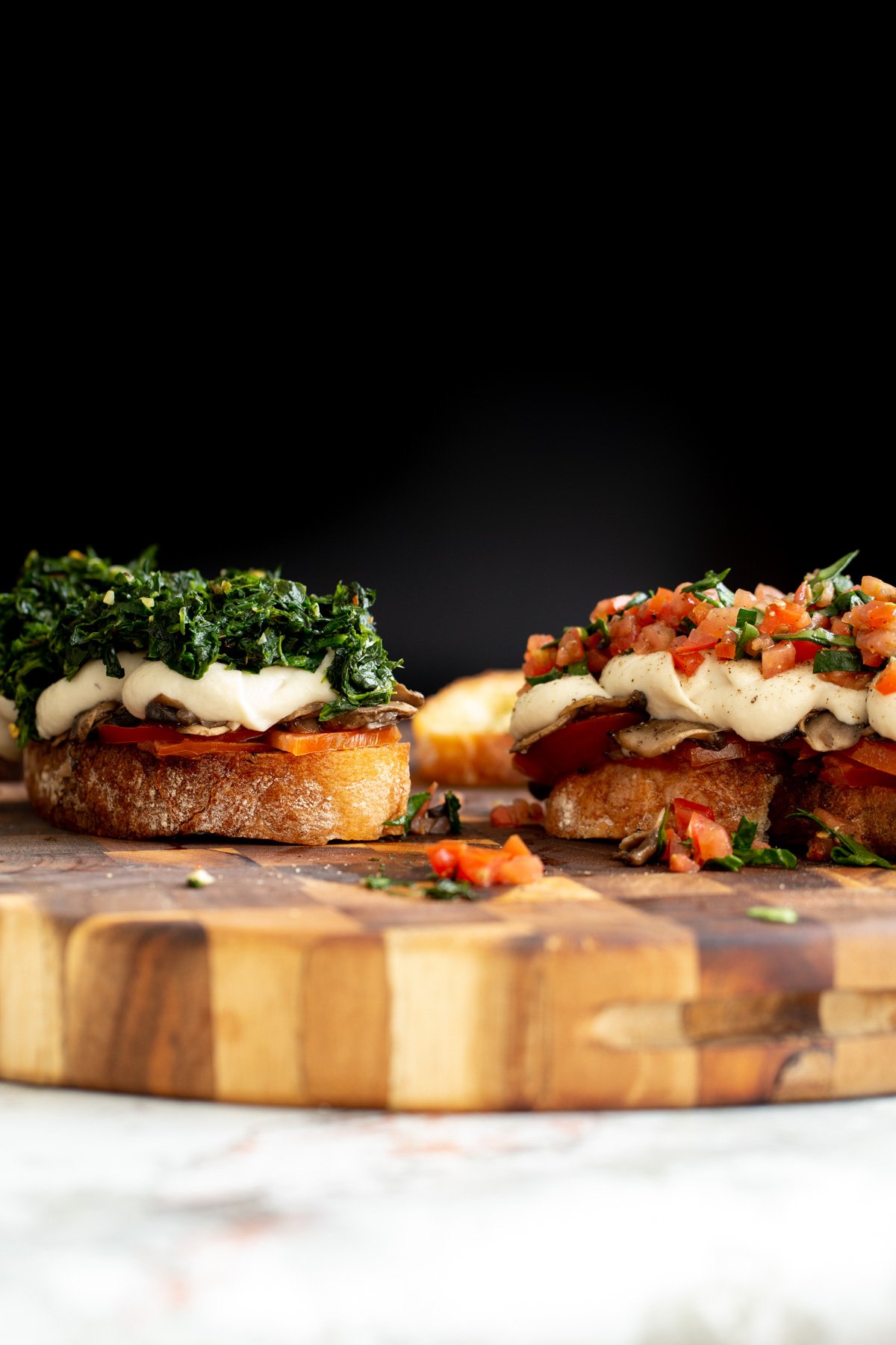 vegan cheese melts  side view of vegan cheese melts topped with spinach and chopped tomatoes