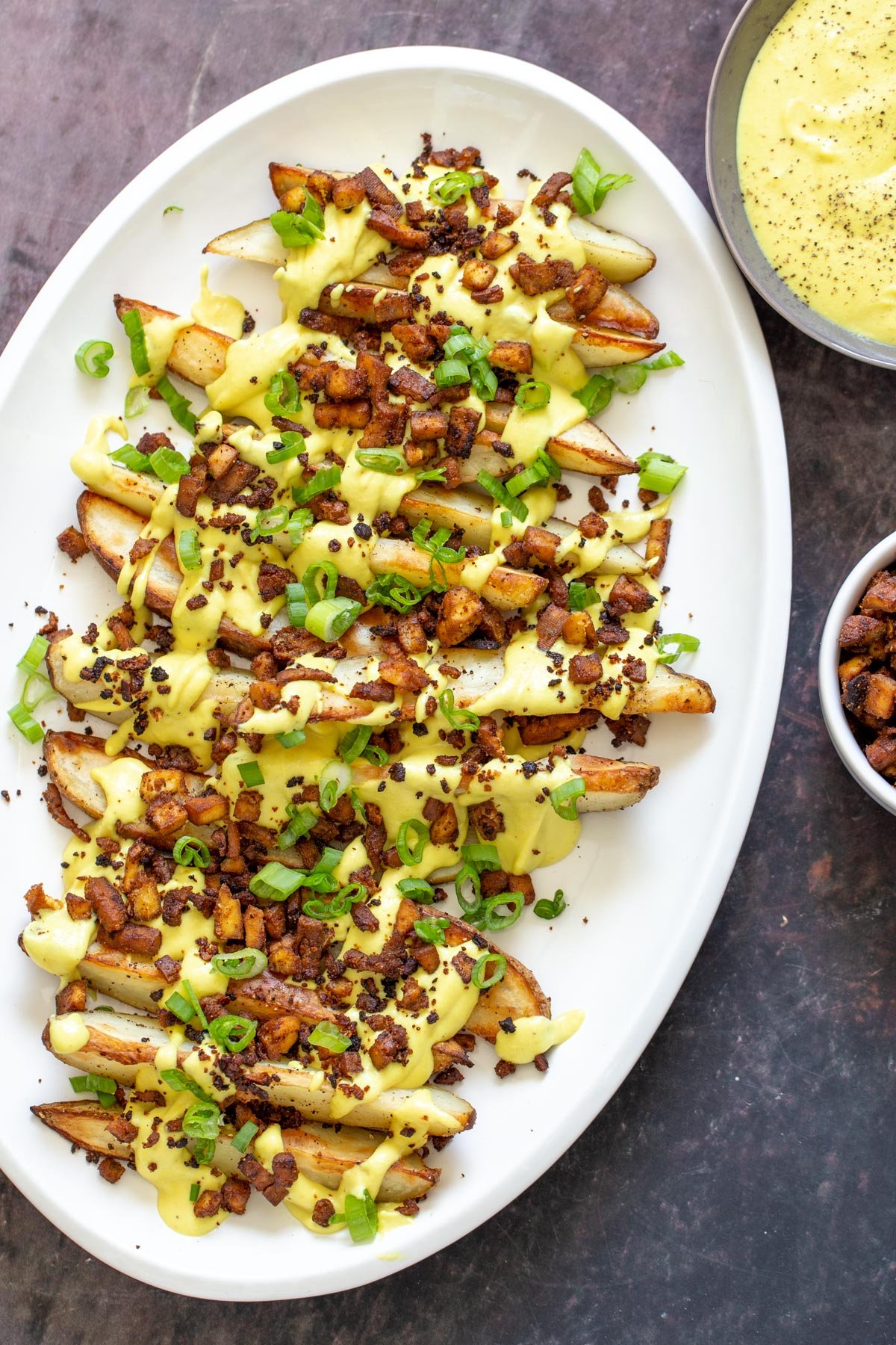 loaded potato wedges  crispy vegan baked loaded fries topped with vegan cheese sauce and tofu bacon bits