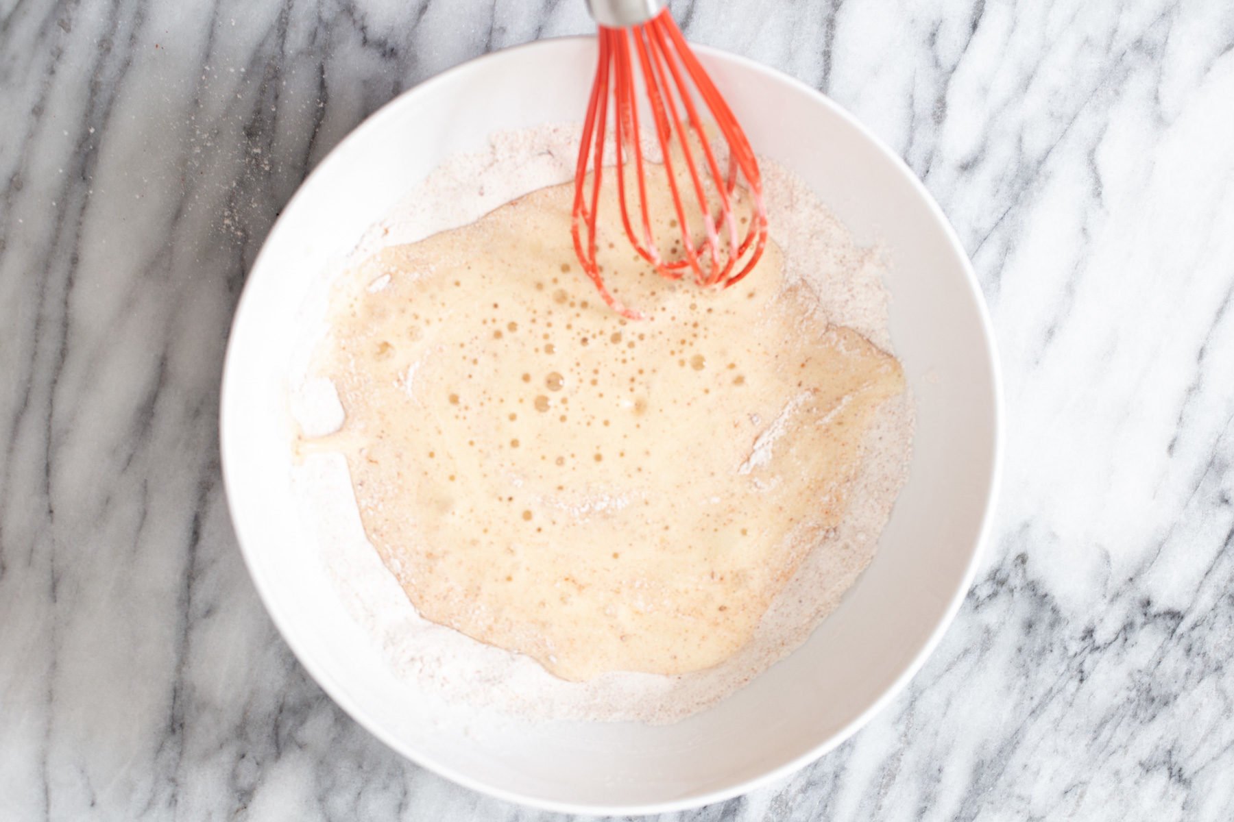 cauliflower wings  vegan beer batter being mixed in a small white bowl