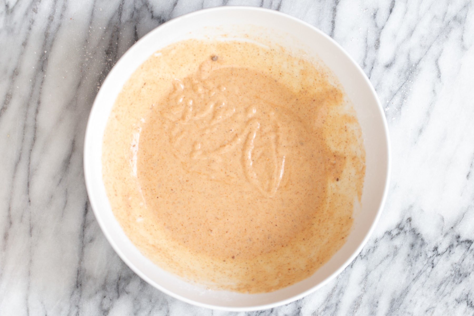 cauliflower wings  beer batter for vegan cauliflower wings in a small white bowl