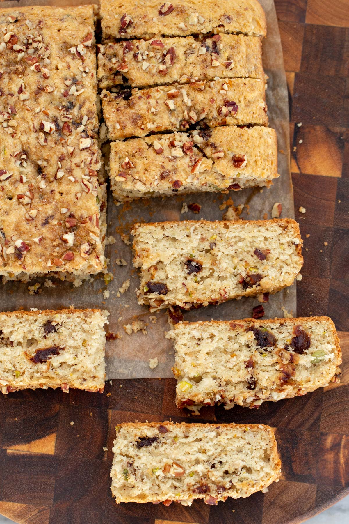 date nut cake vegan date nut cake being cut into slices on a wooden board