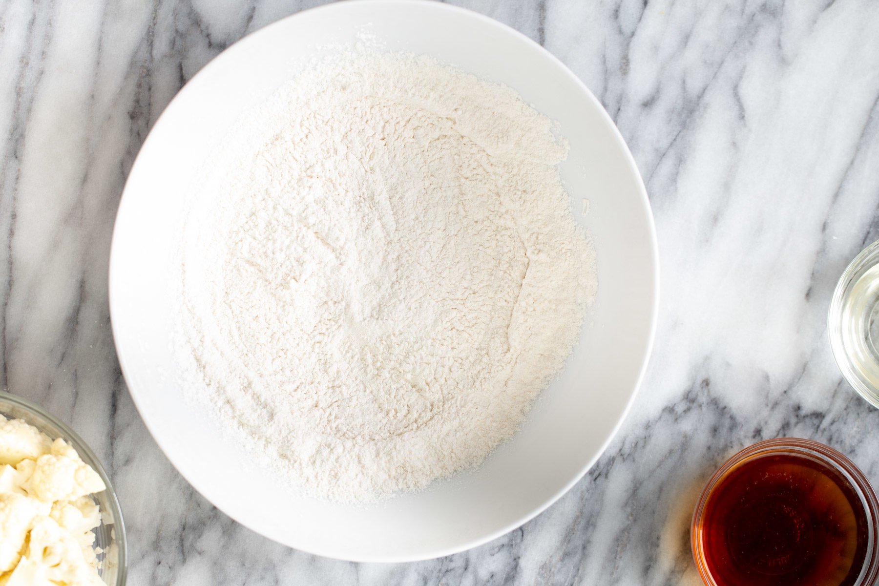 cauliflower manchurian  dry mix for cauliflower manchurian batter in a white bowl