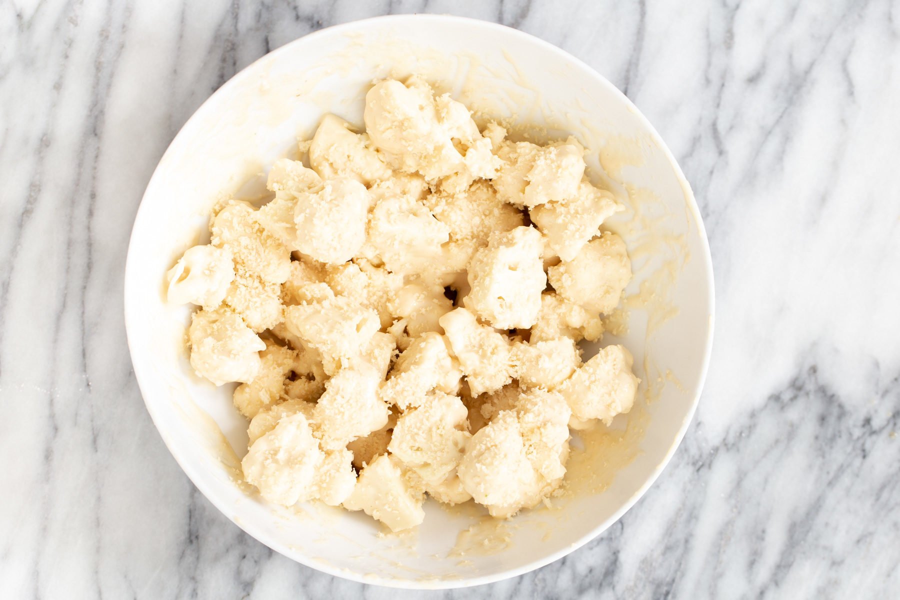 cauliflower manchurian  battered cauliflower florets being tossed with panko to make cauliflower manchurian