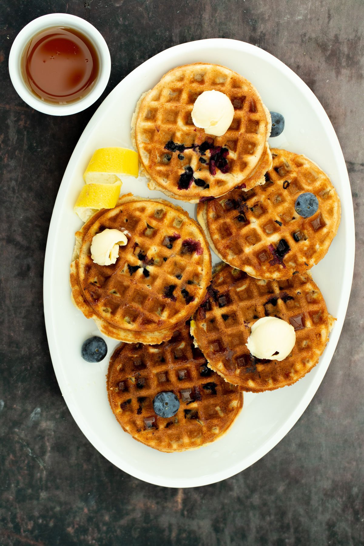 glutenfree lemon blueberry waffles a white platter with glutenfree vegan lemon blueberry waffles served with a side dish of maple syrup