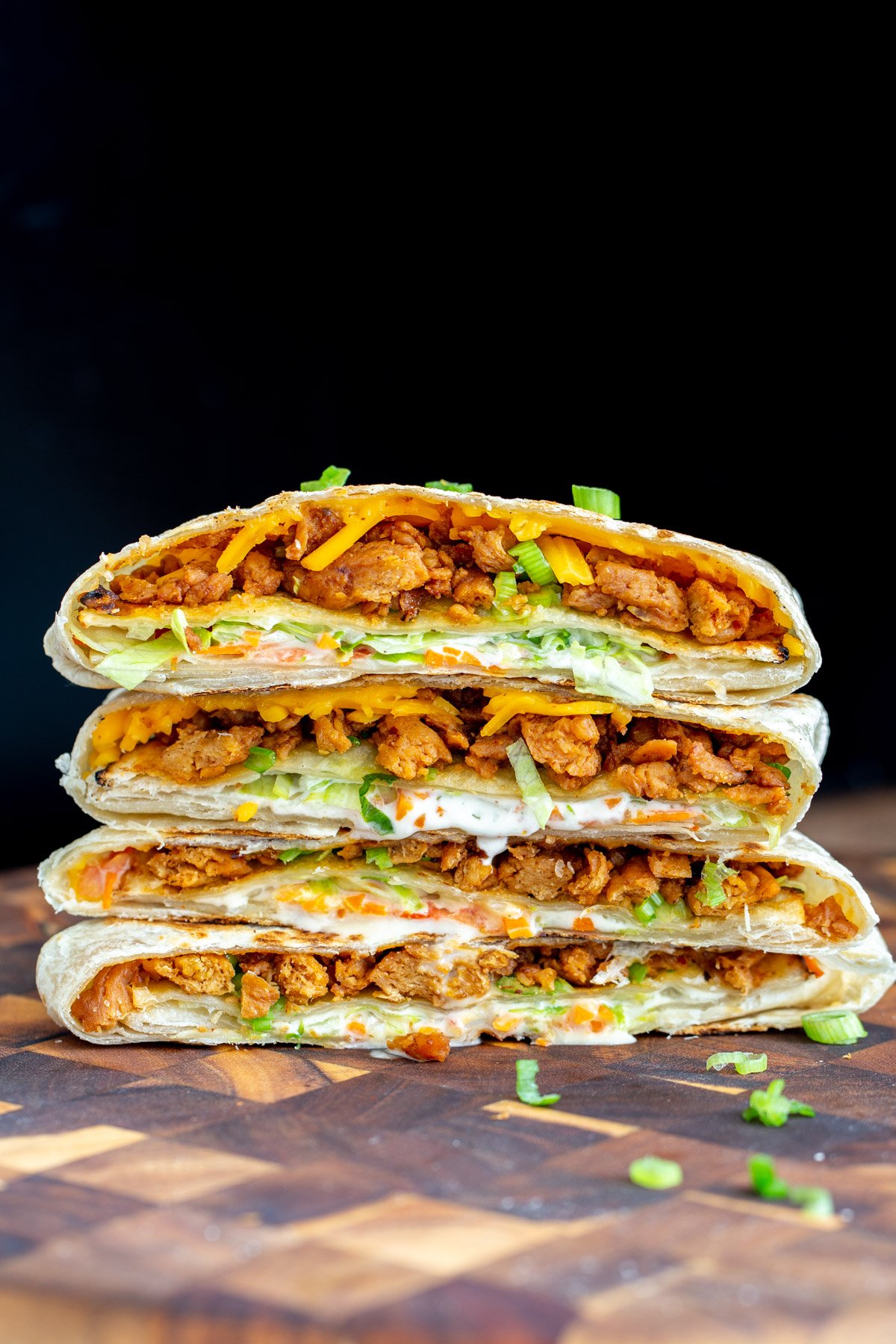 vegan crunchwrap  vegan Korean bbq crunchwrap stacked on a wooden board