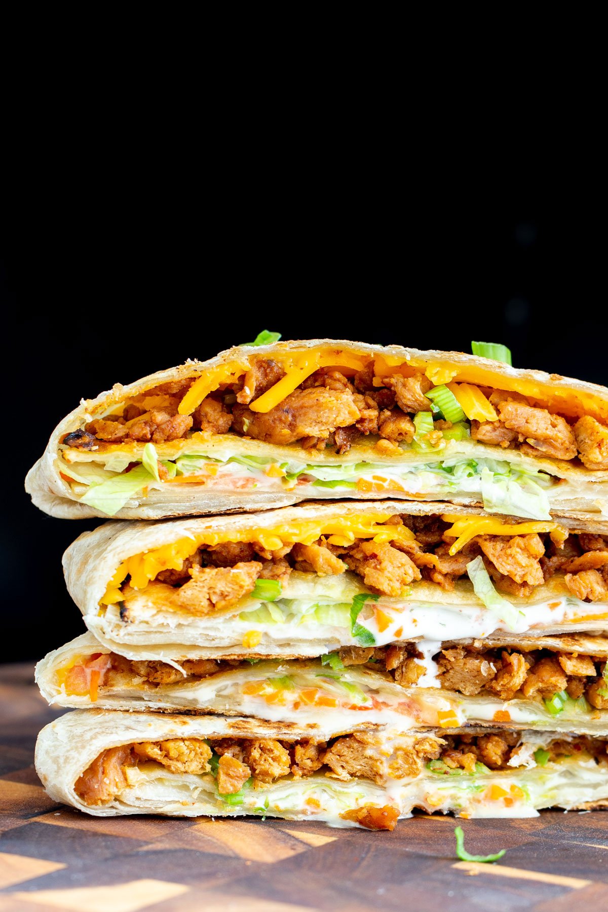 vegan crunchwrap a stack of halved vegan crunchwraps filled with Korean BBQ soycurls, vegan cheese, veggies and Ranch