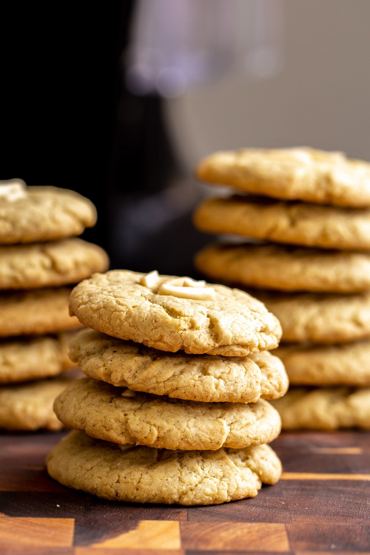 pistachio cookies stacked vegan pistachio cookies topped with slivered almonds on a wooden chopping board