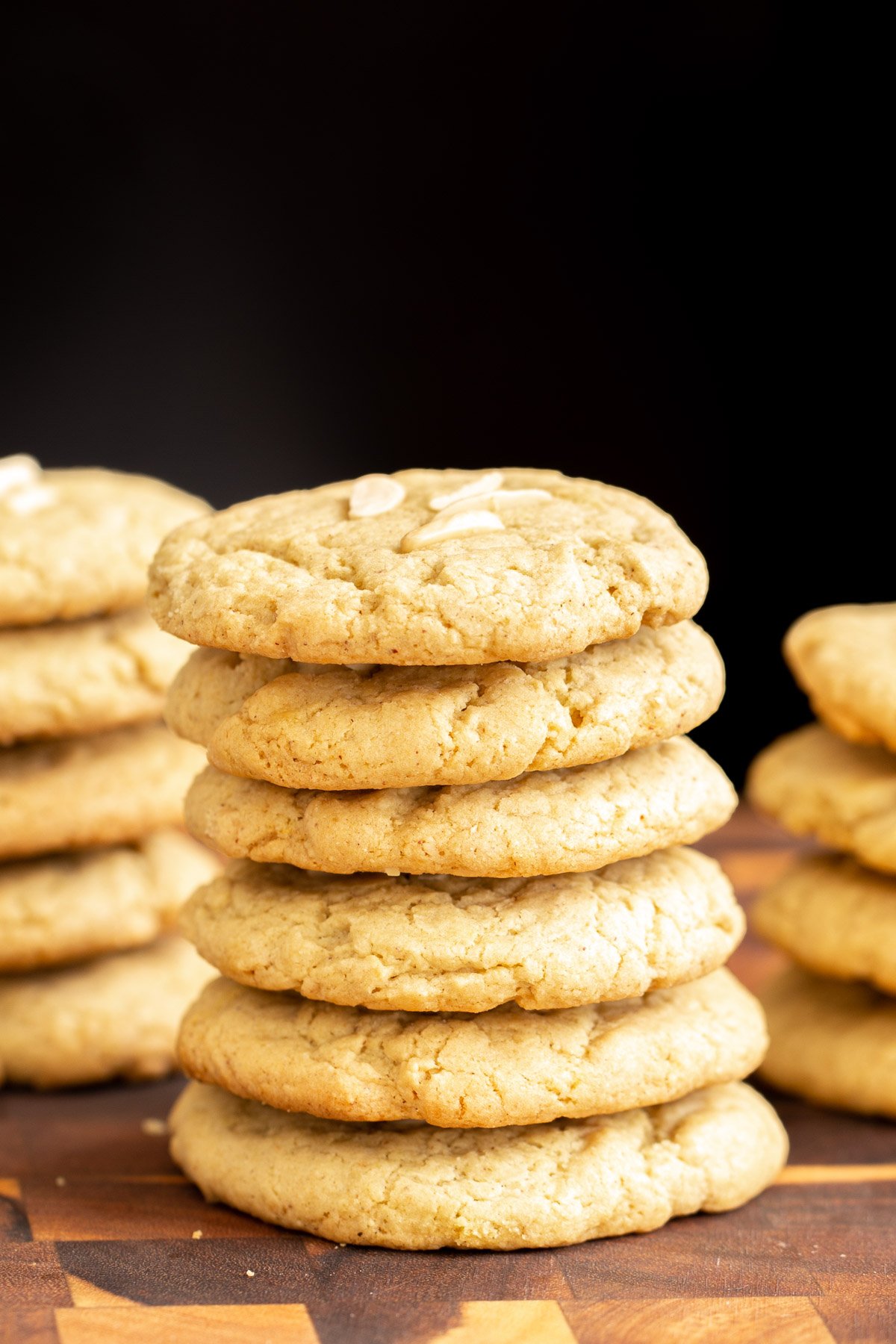 pistachio cookies side view of a stack of vegan almond pistachio cookies on a wooden board