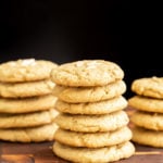 vegan pistachio cookies stacked on a wooden board