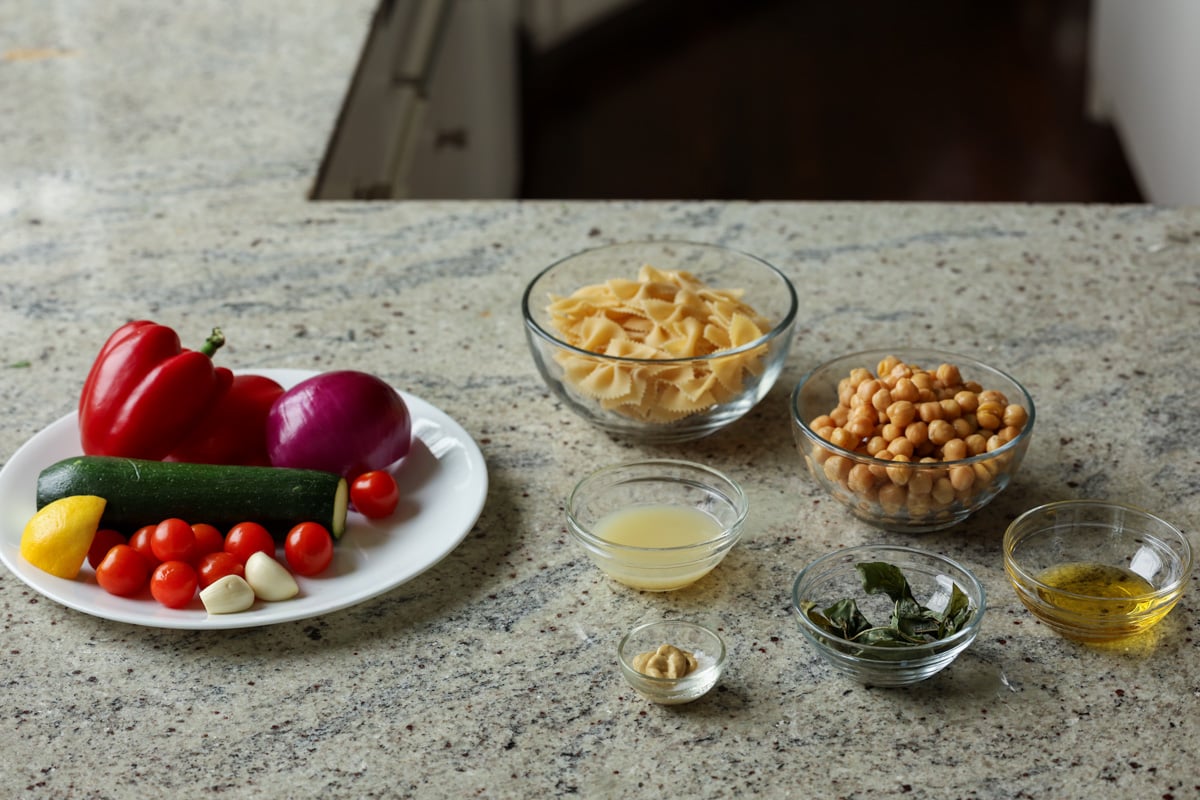 pasta salad and grilled vegetable ingredients on the kitchen counter