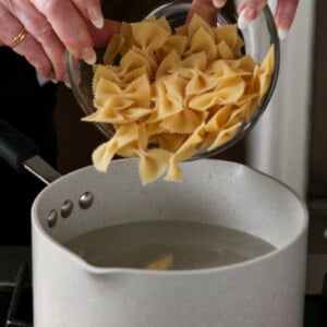 adding pasta to the pot of boiling water