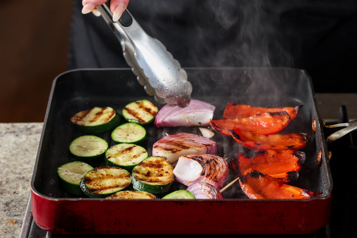 flipping the vegetables on the grill pan