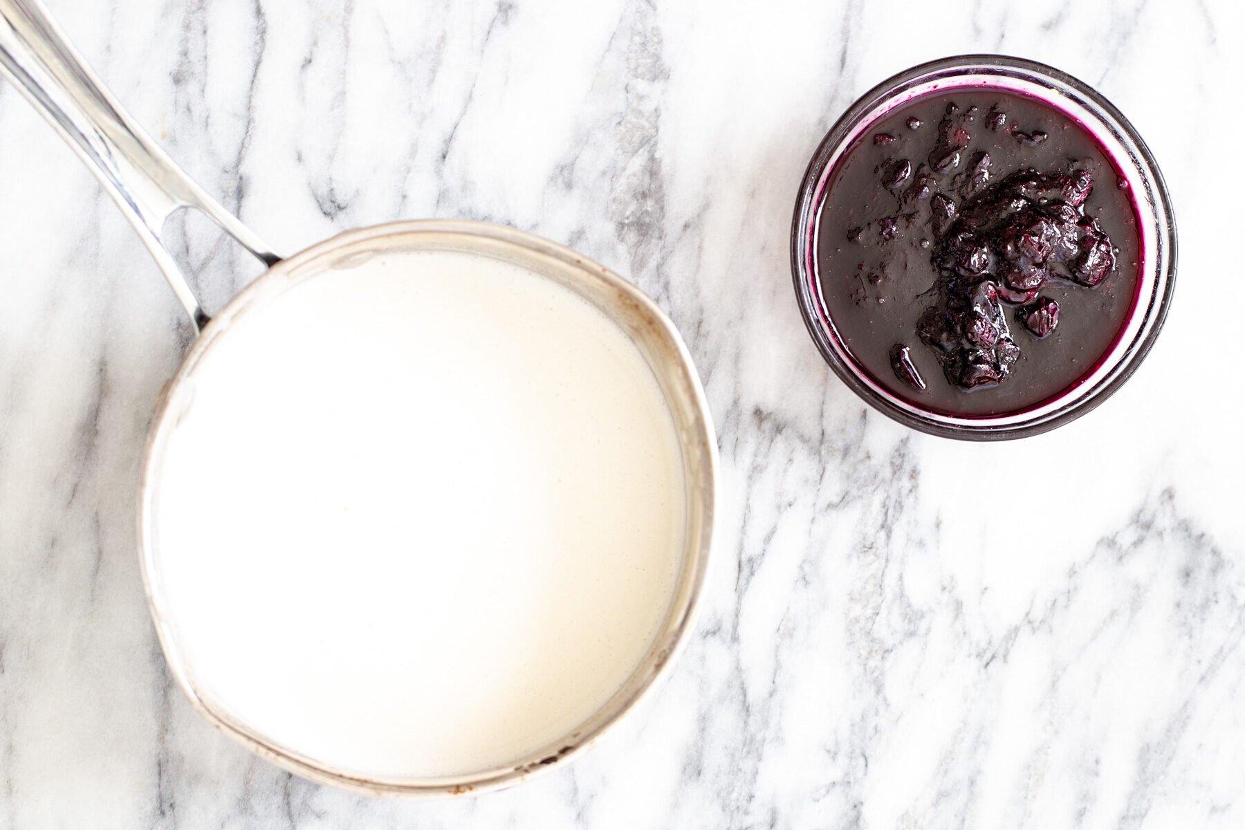 vanilla ice cream sandwiches  a pot with vegan vanilla ice cream base next to a small dish with blueberry compote