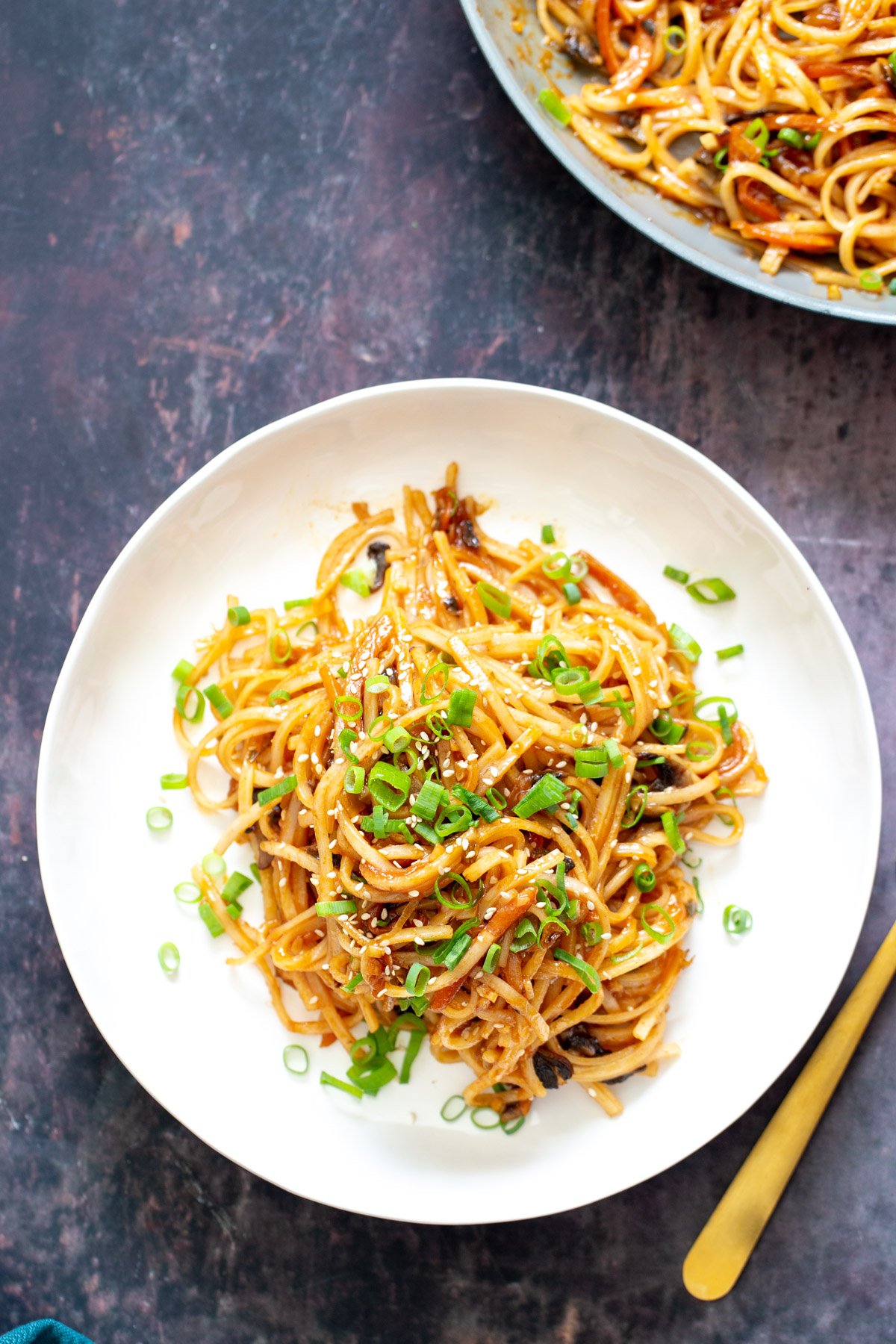 gochujang noodles a plate of gochujang noodles topped with sliced spring onions and sesame seeds