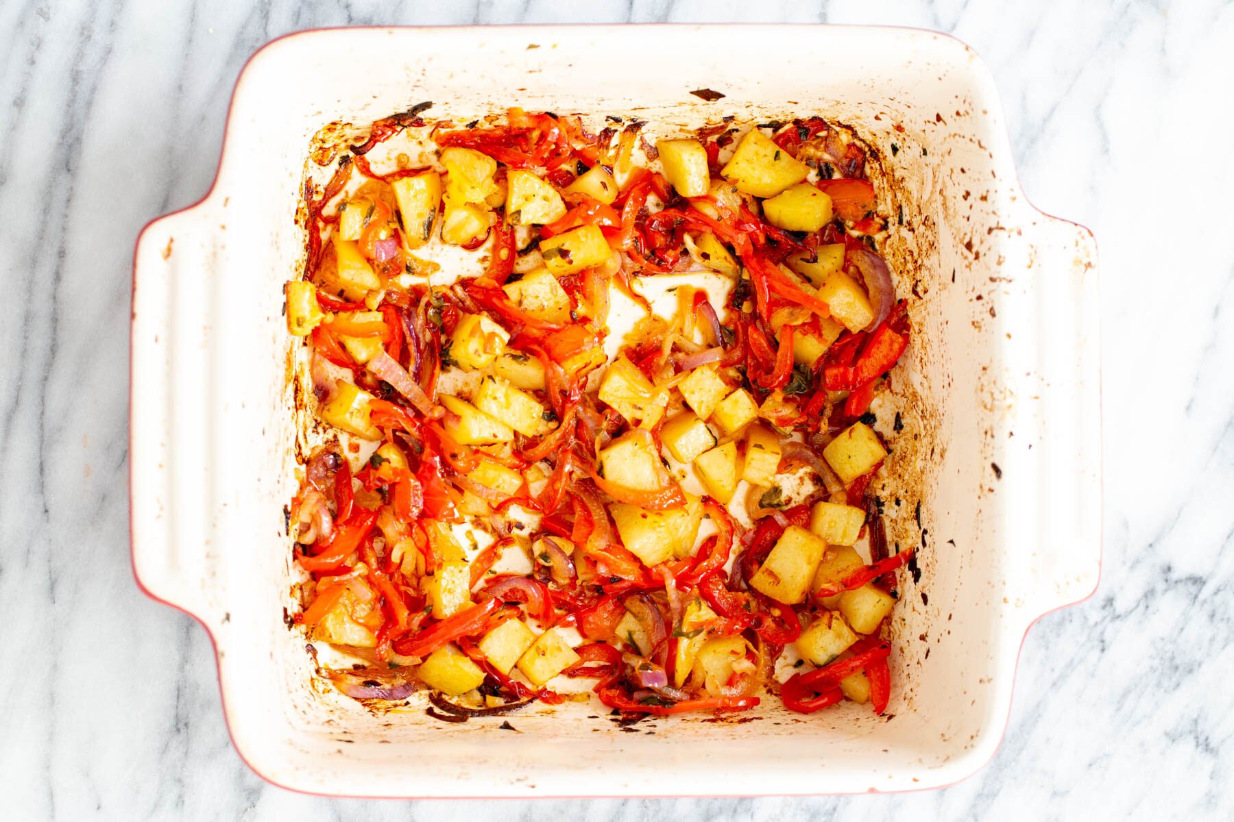 vegan Mexican casserole  roasted bell peppers, onion and potatoes in a casserole dish