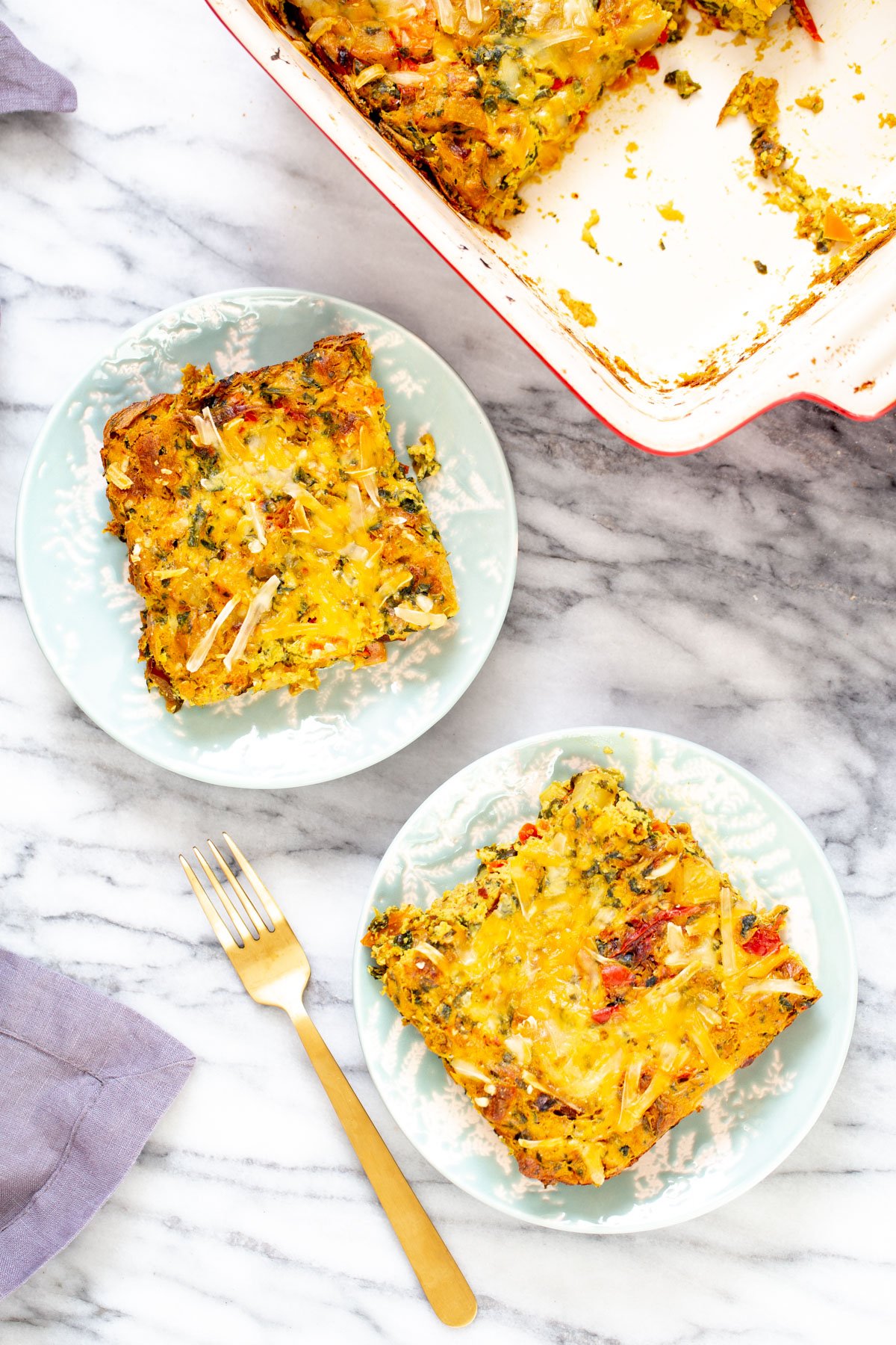 vegan Mexican casserole overhead shot with two plates with vegan Mexican egg breakfast casserole topped with cheese