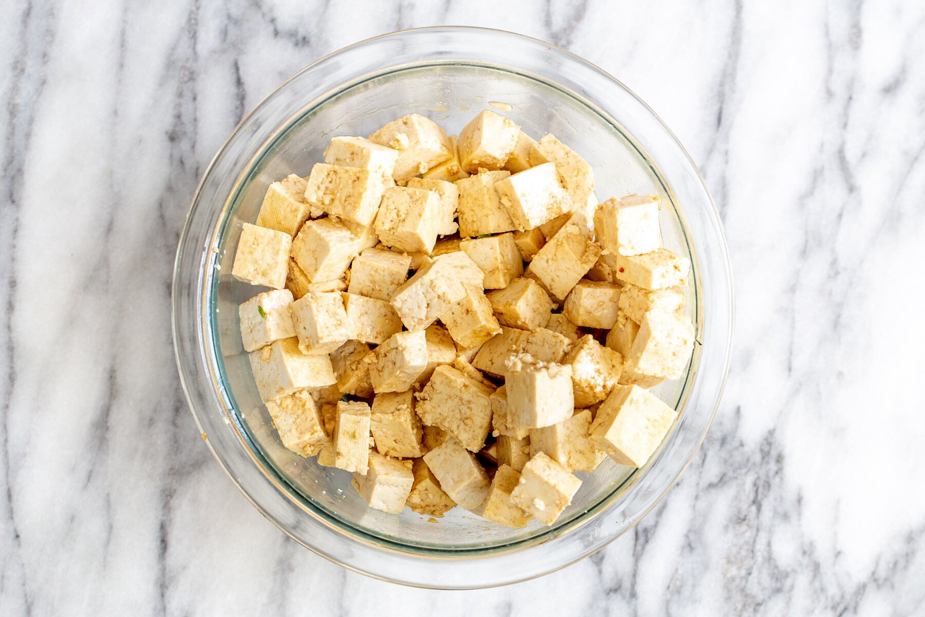 a bowl of pressed tofu tossed in marinade