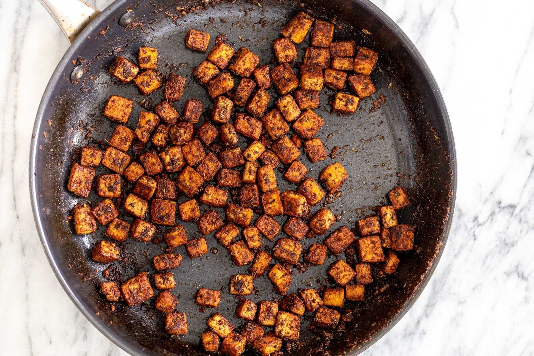 blackened tofu tacos tofu cubes covered in spices in a black skillet