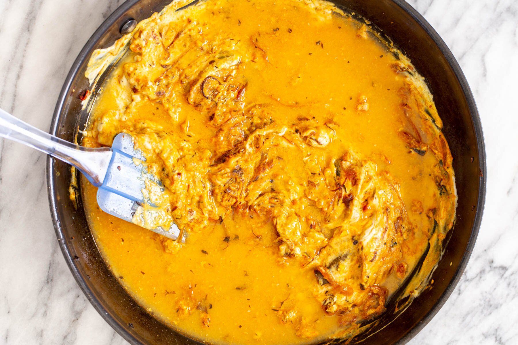 creamy onion gravy in a black saucepan