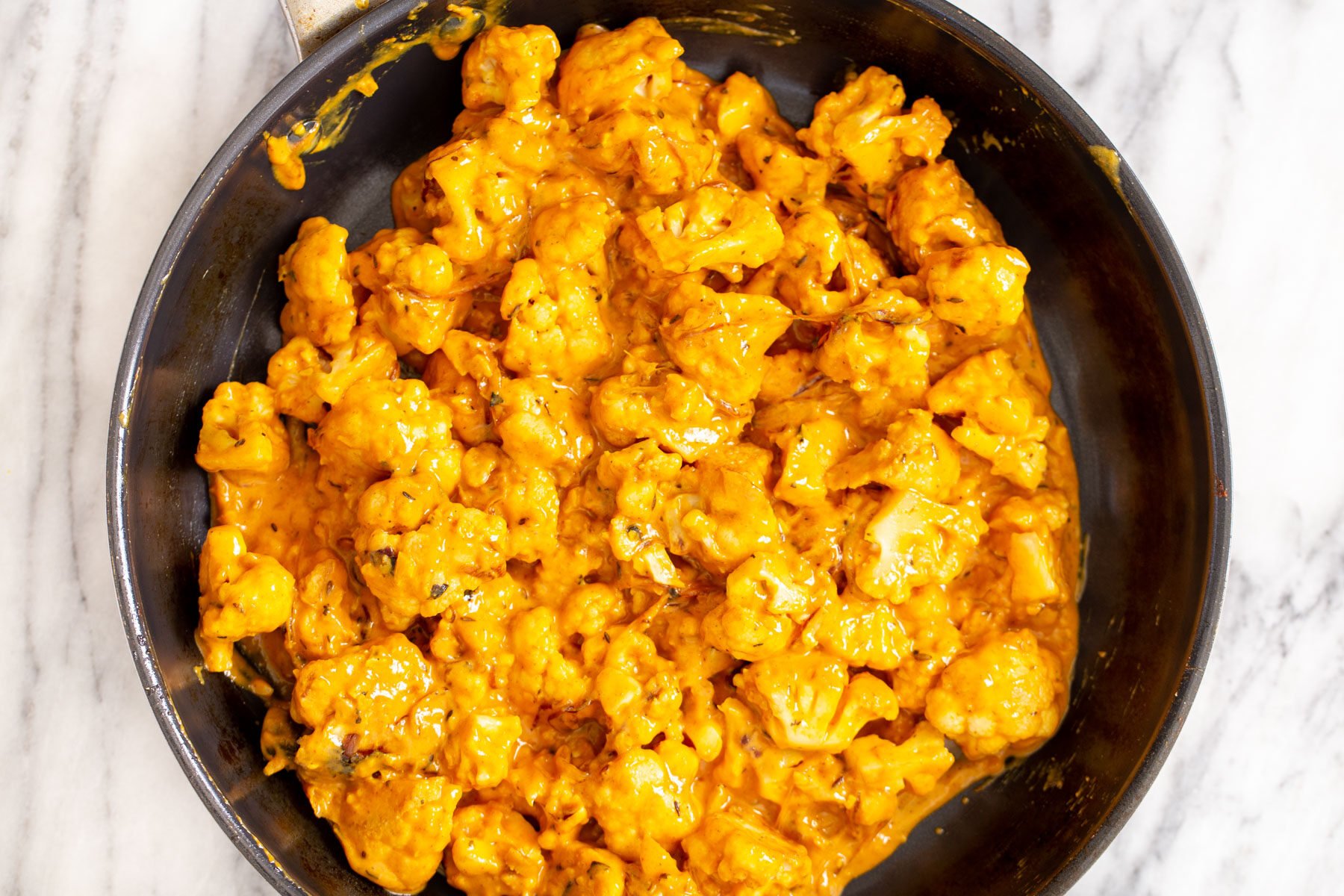 cauliflower simmering in tomato yogurt gravy