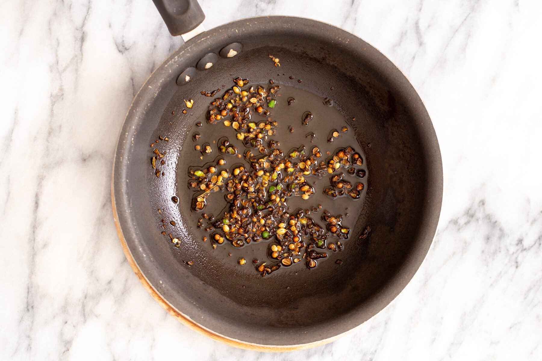 whole spices simmering in hot oil to make temering mixture for curry
