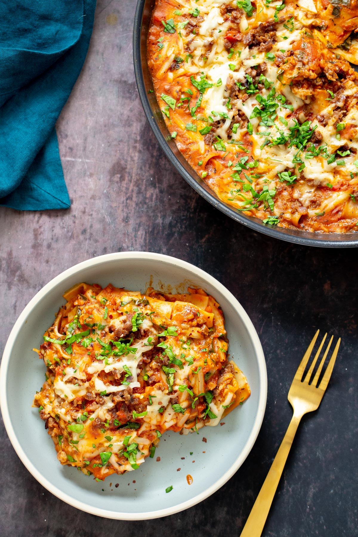 a portion of vegan cast iron skillet lasagna sprinkled with fresh herbs