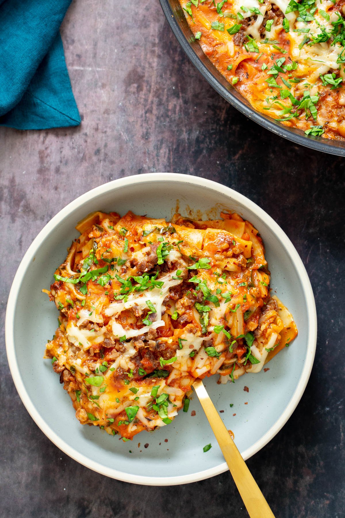 a plate of vegan lasagna sprinkled with chopped parsley