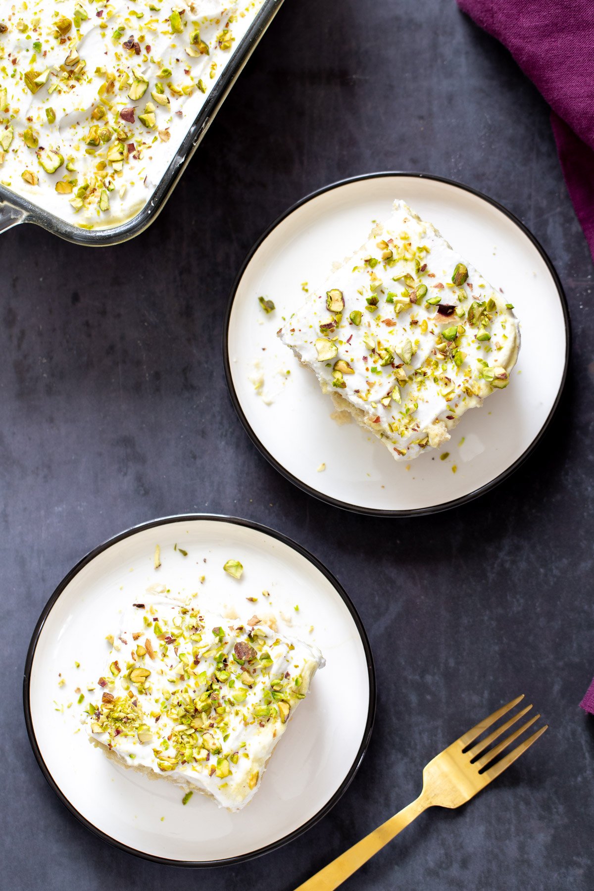 vegan tres leches  overhead shot of two slices of vegan tres leches sprinkled with pistachios