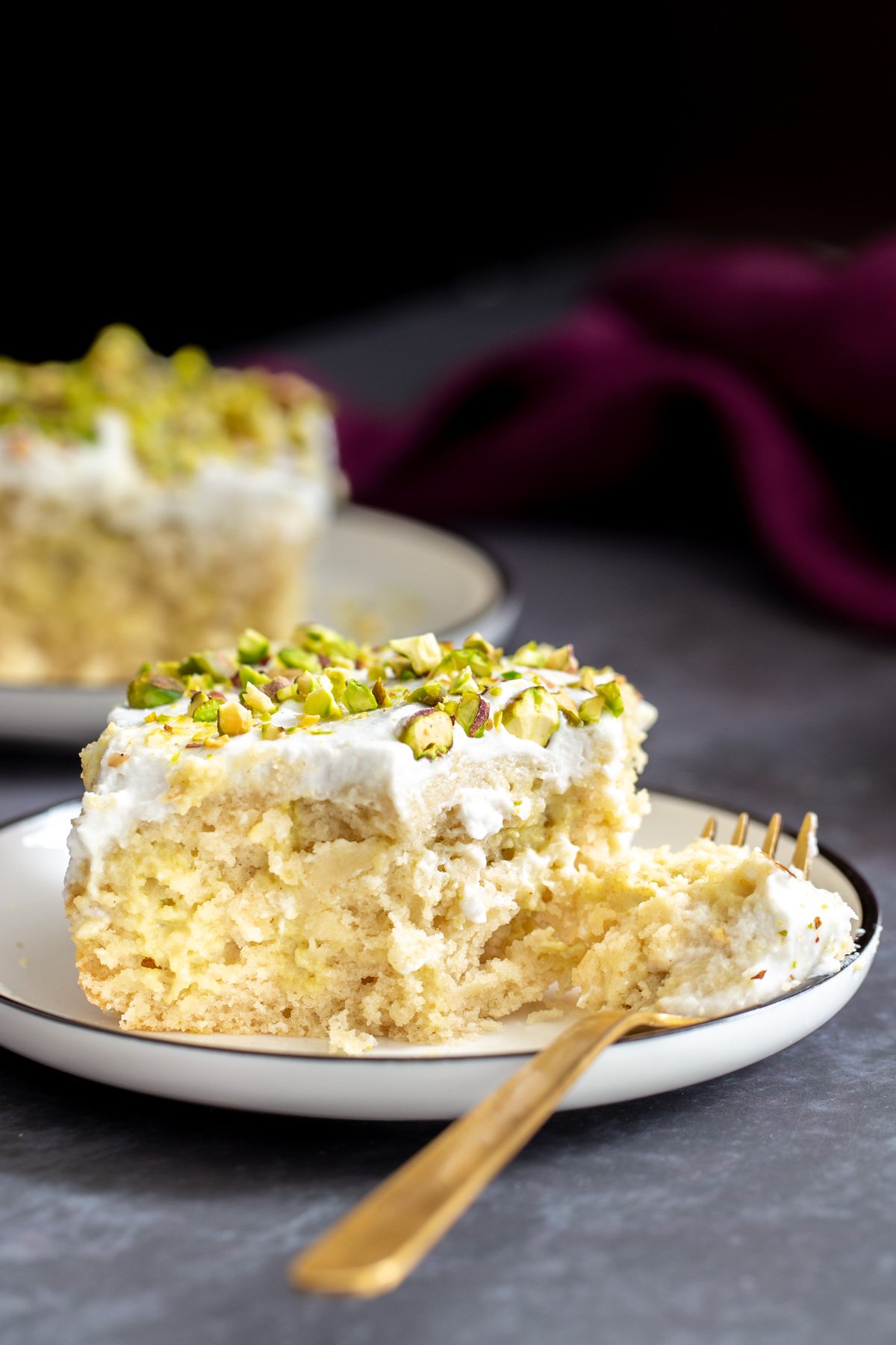 vegan tres leches  a half eaten piece of vegan ras malai tres leches cake with a golden fork on the side