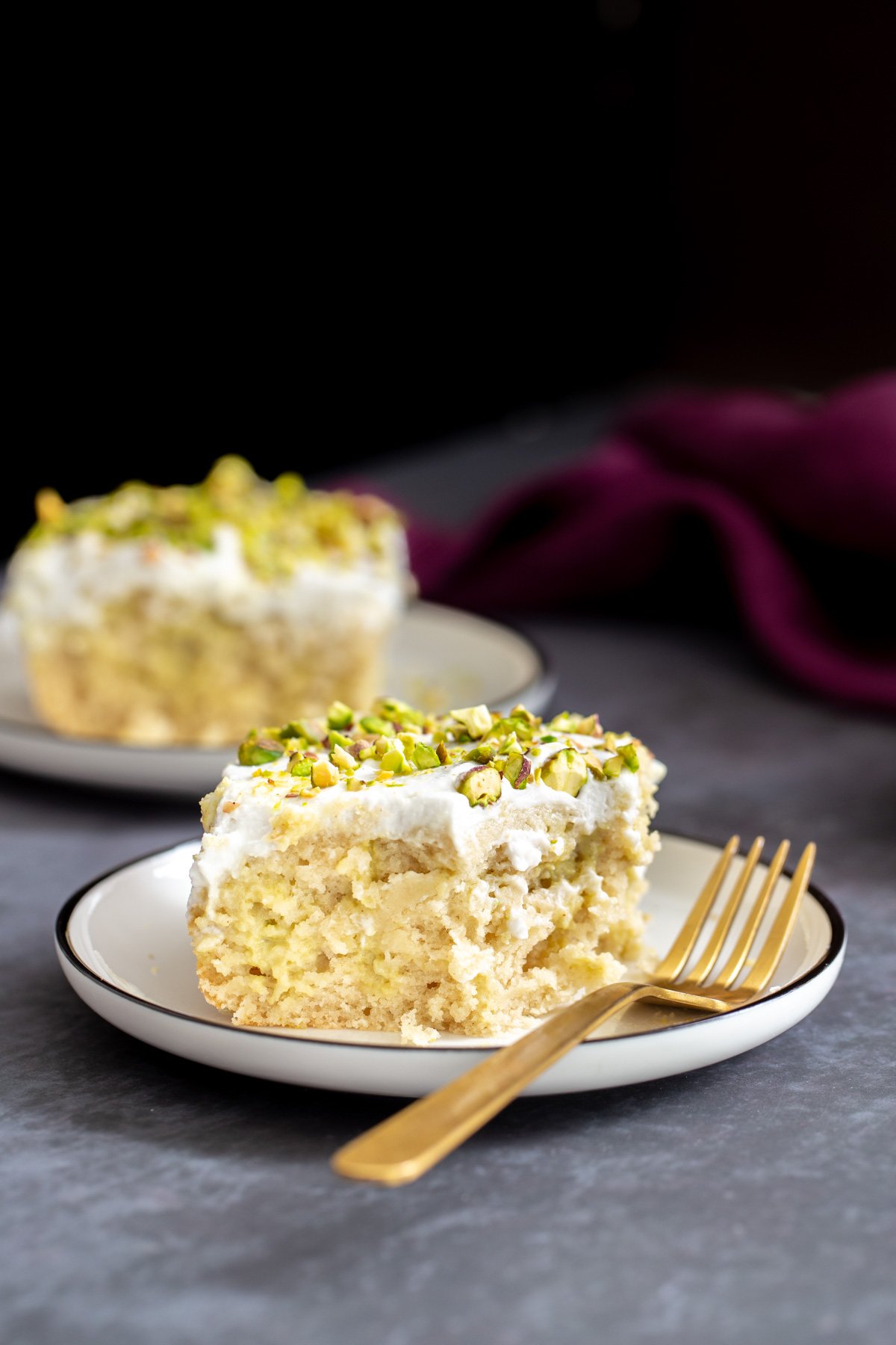 vegan tres leches two slices of vegan ras malai tres leches cake on a grey table