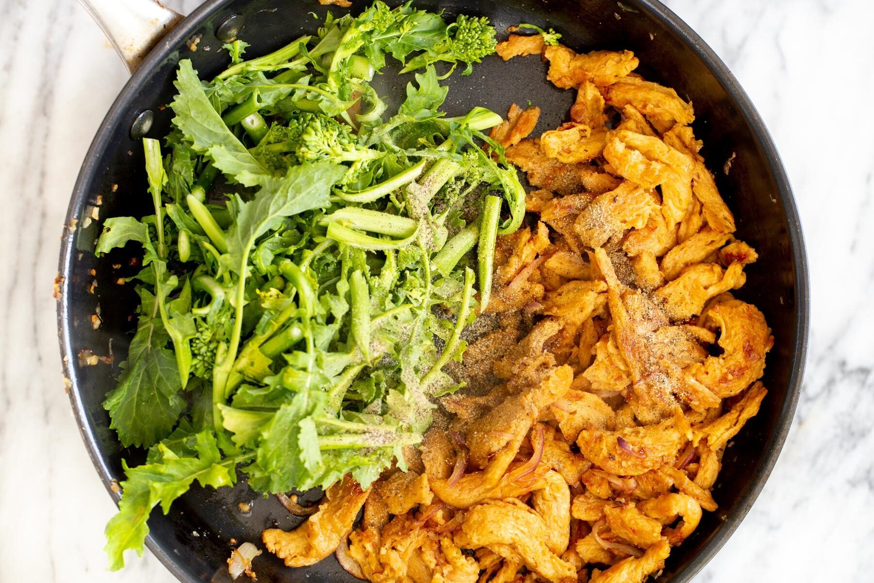 chinese broccoli and fried soy chunks in a sauteeing pan