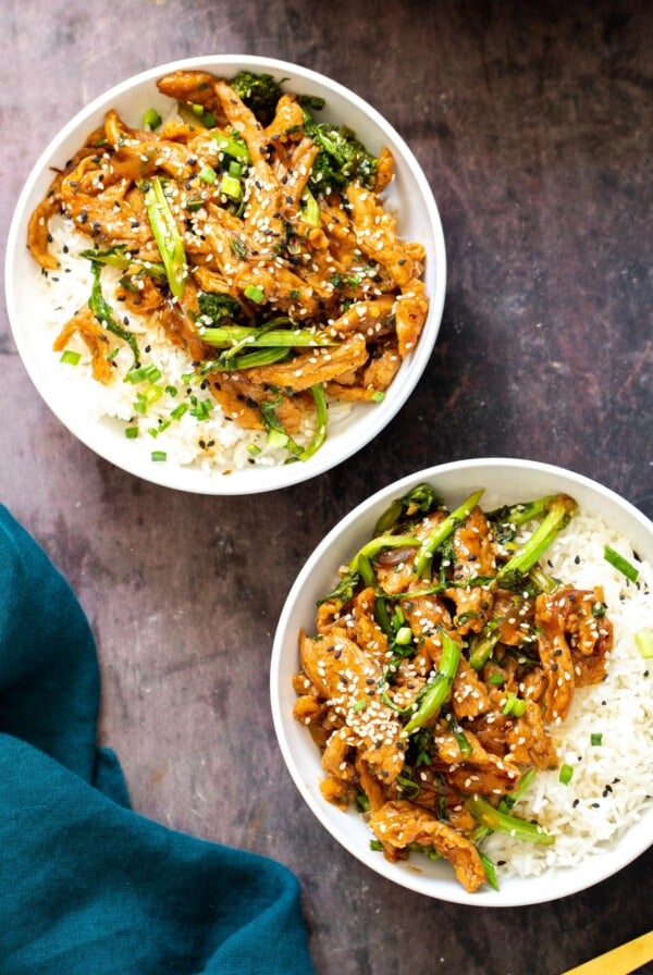 two plates with Sesame Shallot Basil Stir Fry With Soycurls and Broccolini