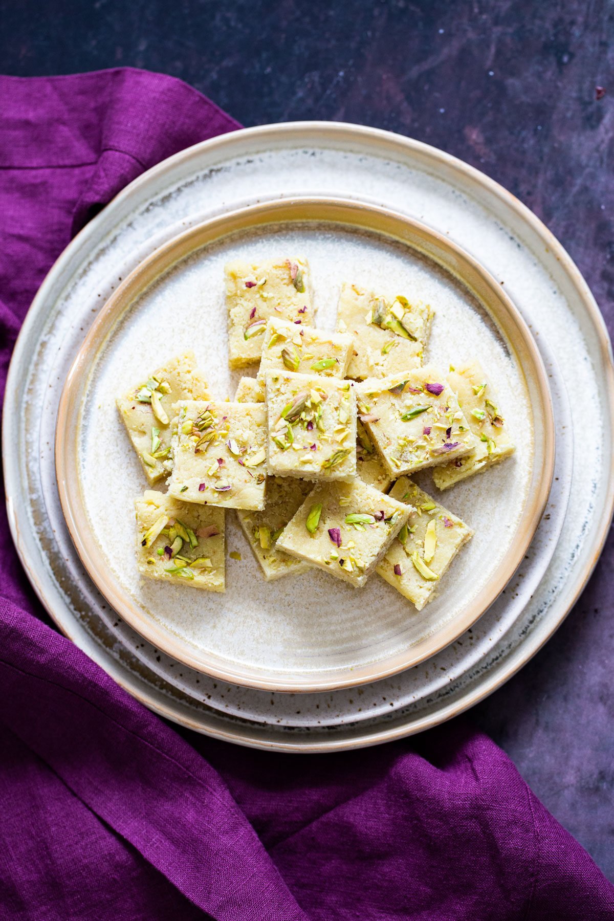 almond burfi a plate with almond burfi topped with chopped pistachios and almonds