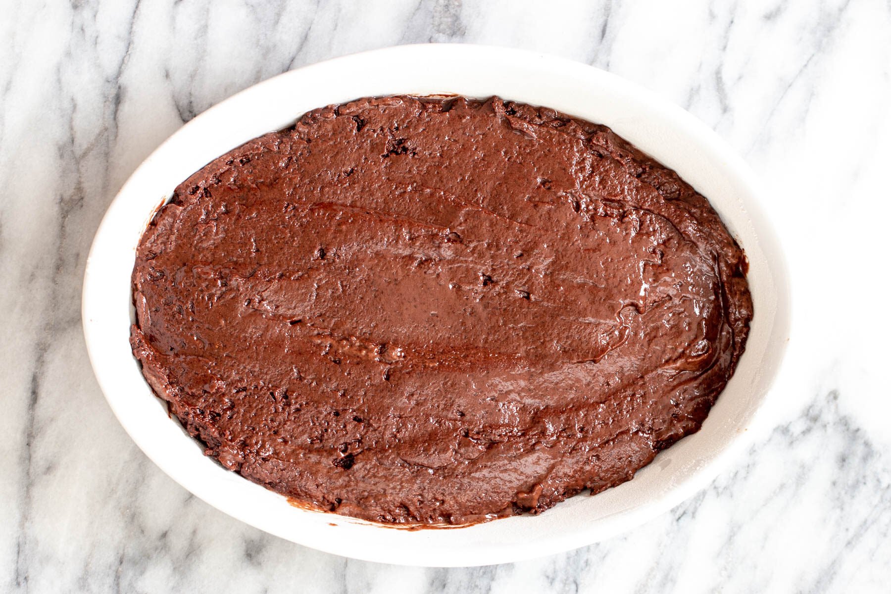 vegan chocolate pudding cake batter in a round casserole dish