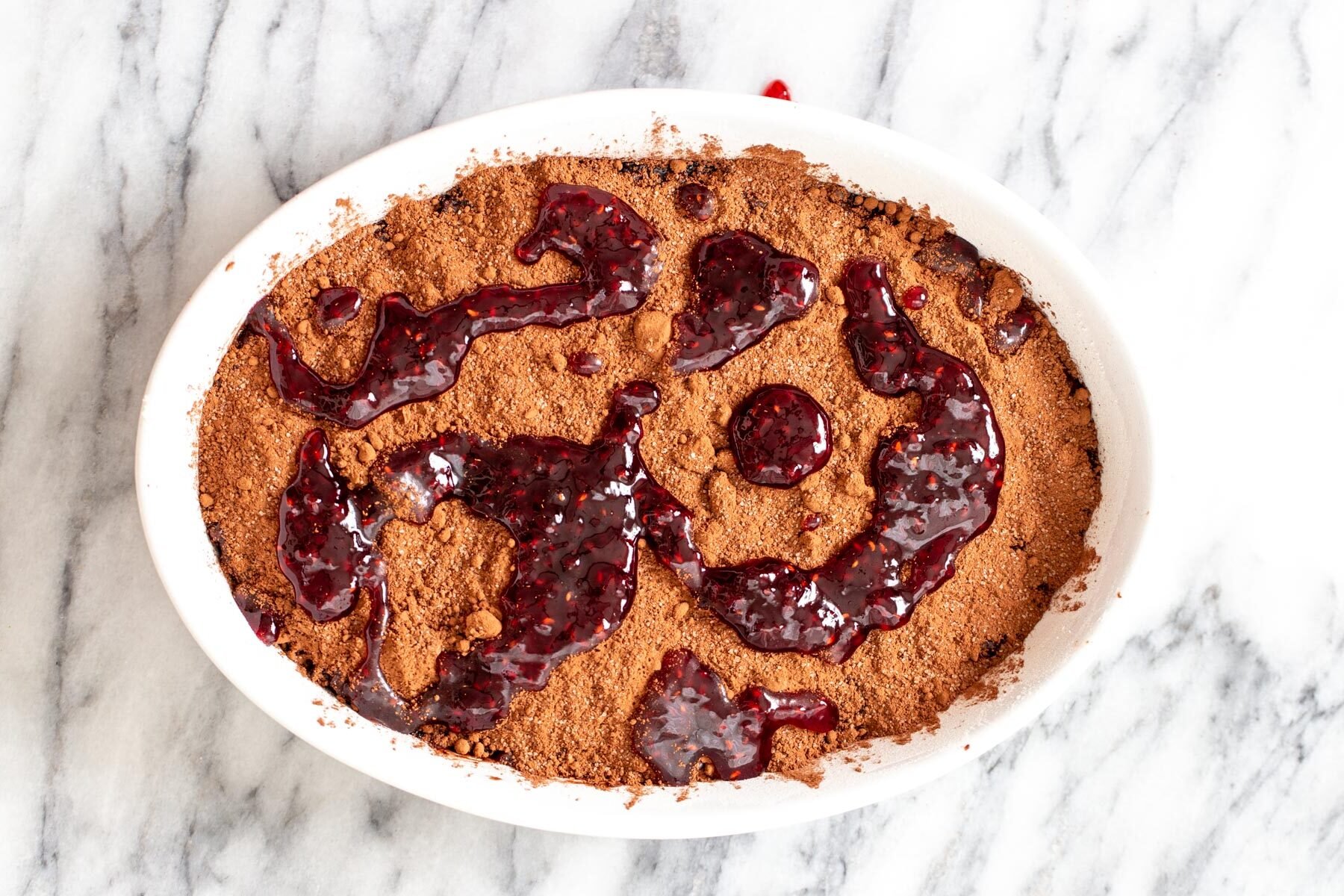 cherry perserved being added to chocolate pudding cake