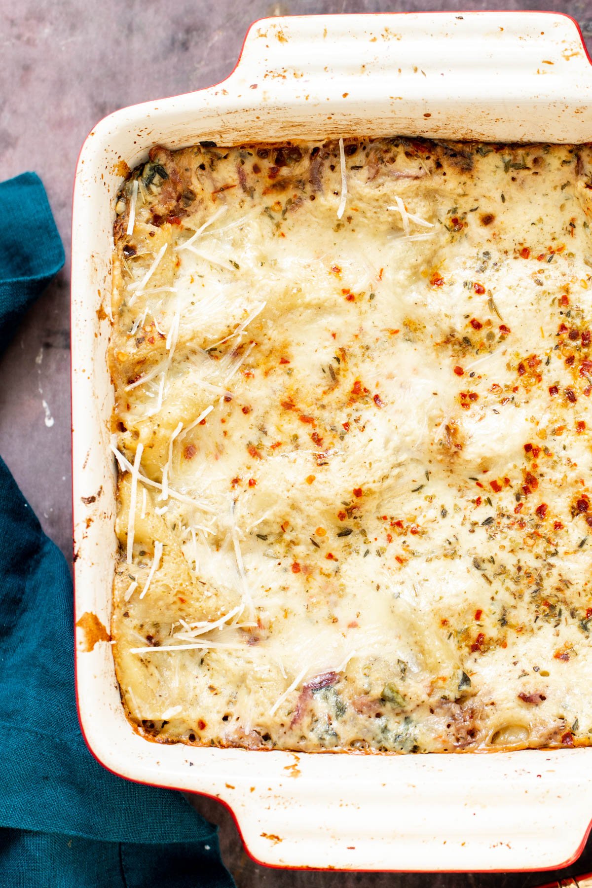 vegan butternut squash lasagna a casserole dish with vegan butternut squash lasagna topped with red pepper flakes