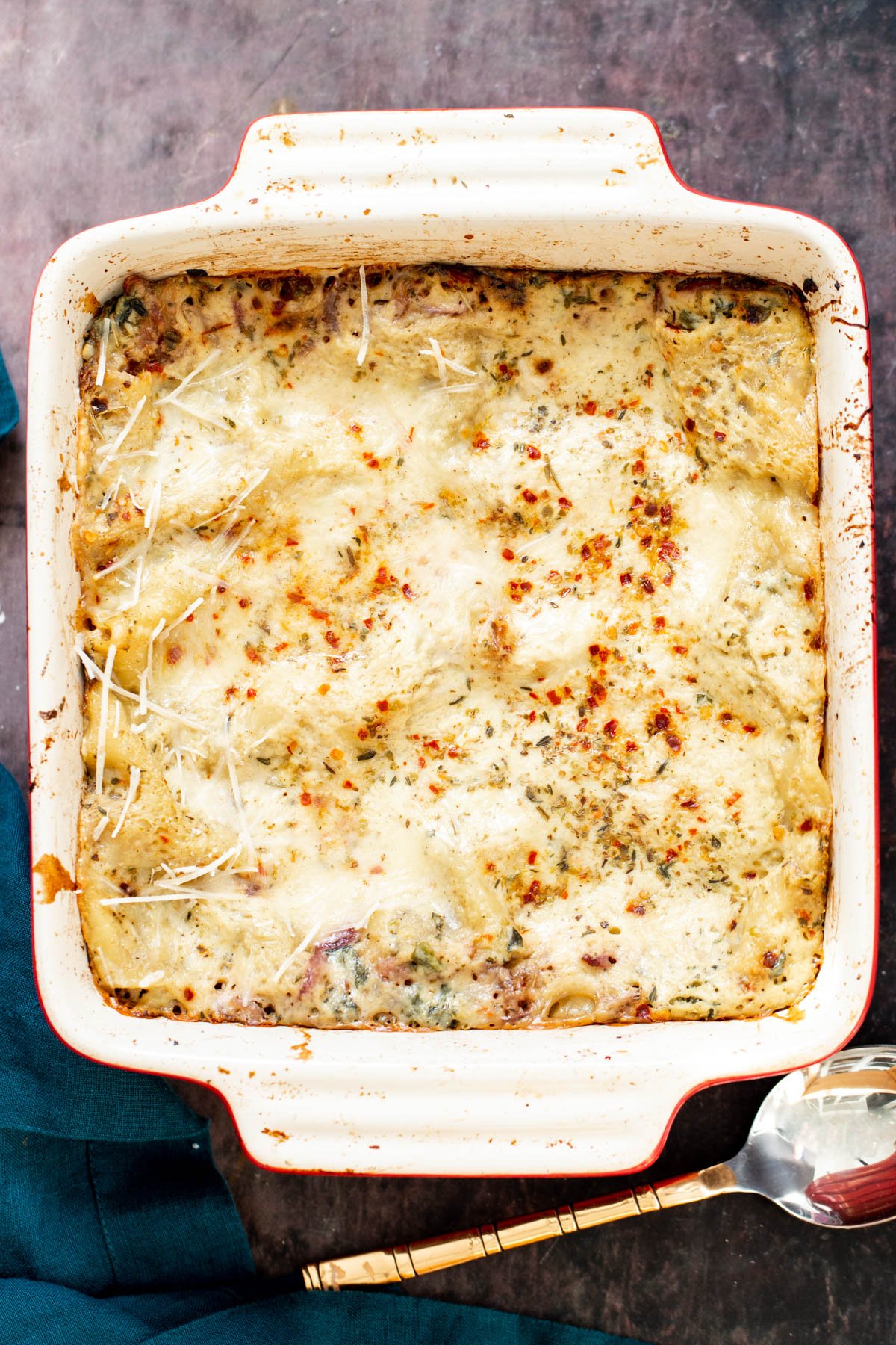 vegan butternut squash lasagna a casserole dish of vegan butternut squash lasagna topped with red pepper flakes