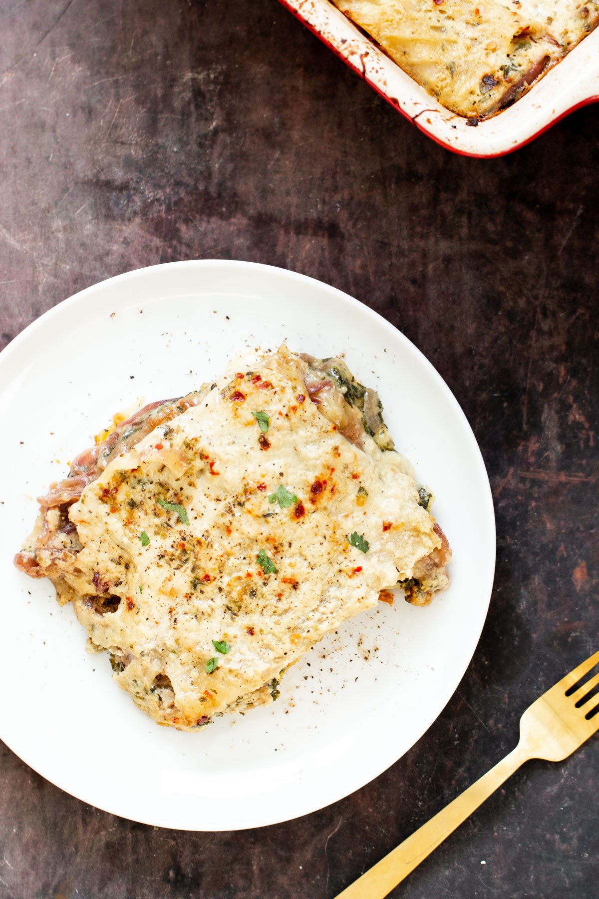 vegan butternut squash lasagna a serving of vegan butternut squash lasagna with spinach on a white plate