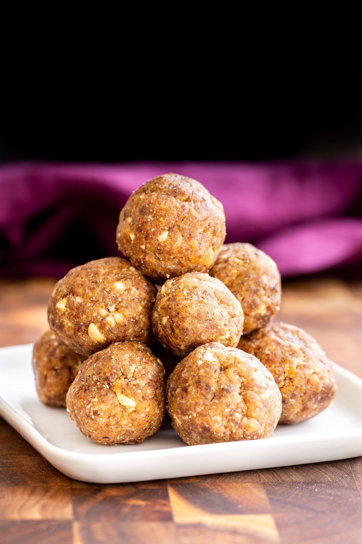 date ladoo a plate with stacked vegan ladoos sweetened with dates
