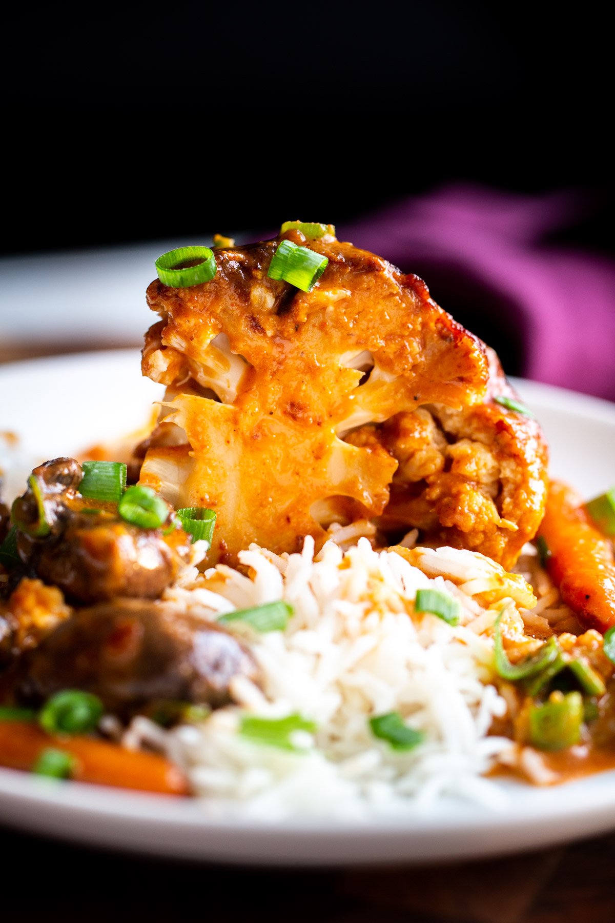 miso roasted cauliflower a wedge of a whole glazed peanut butter miso roasted cauliflower served with rice