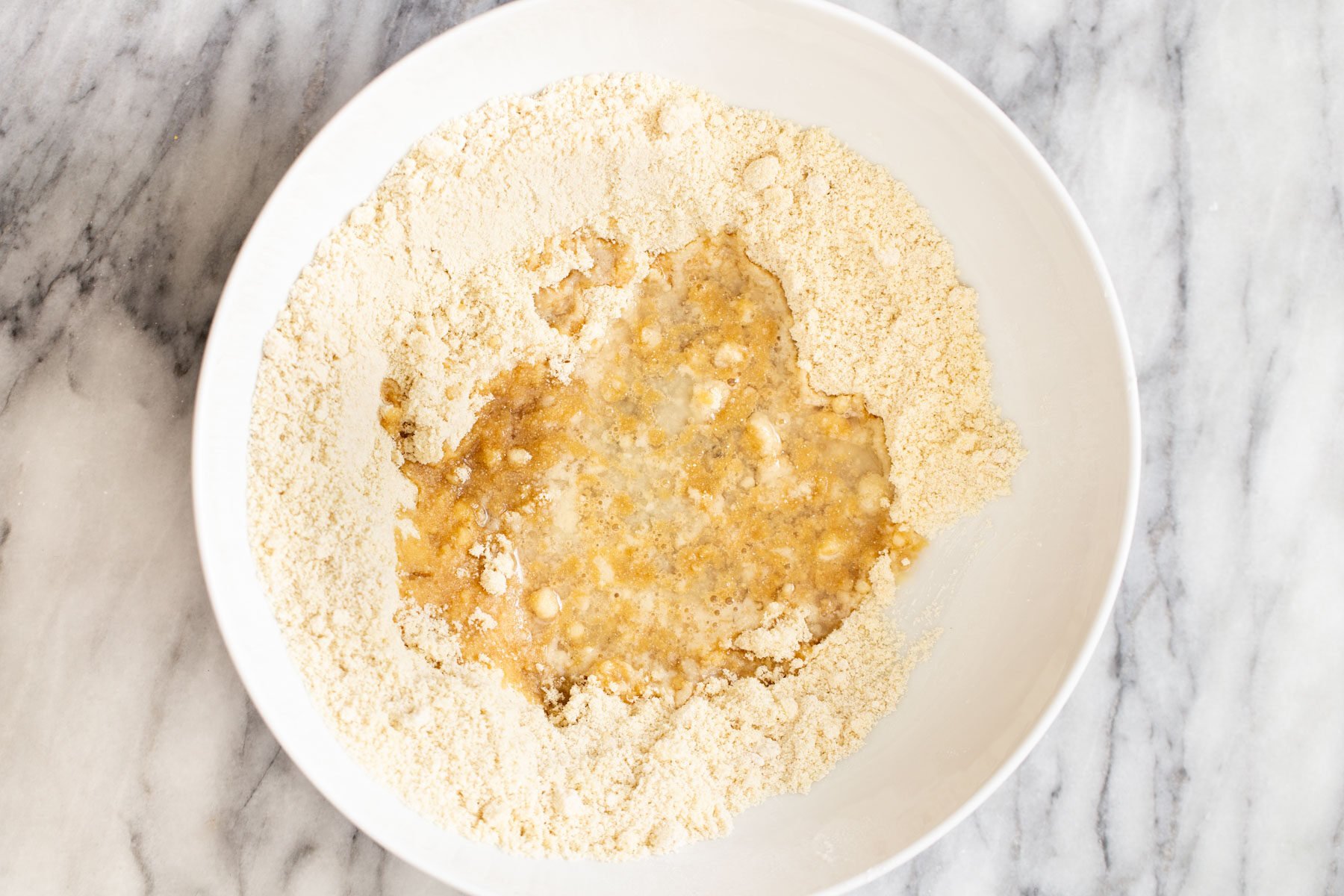 vegan pecan pie bars  coconut oil being added to dry mix to make base for vegan pecan pie bars