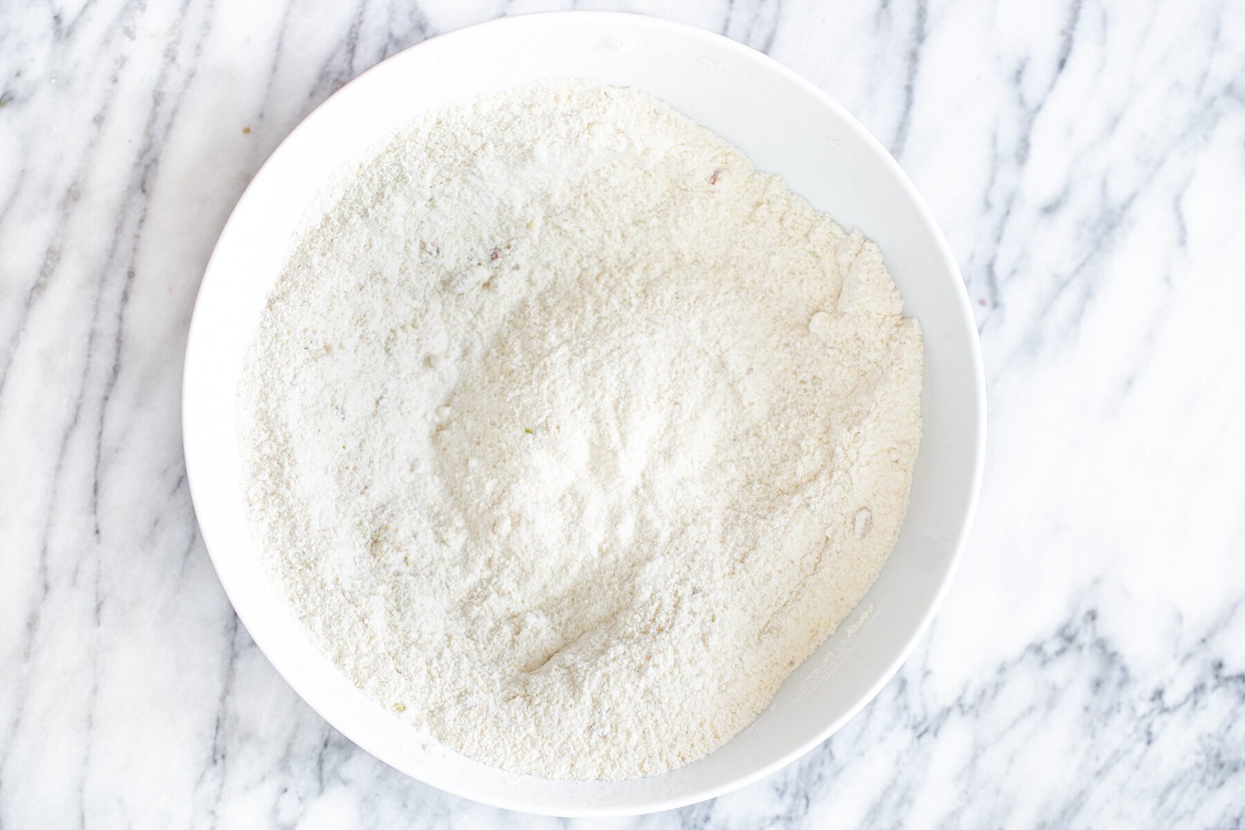 dry ingredients for vegan tres leches cake in a white bowl