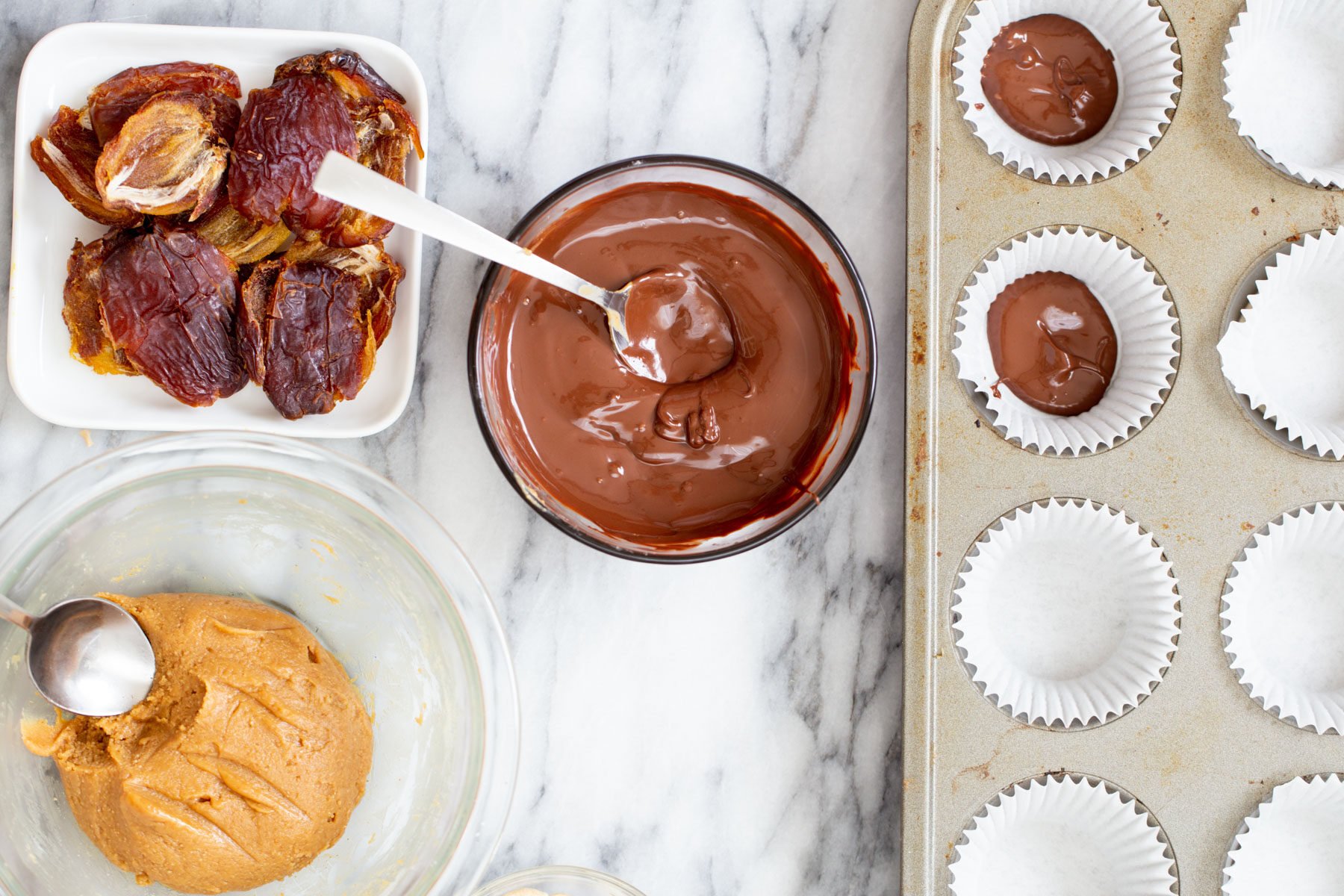 vegan snickers cups melted chocolate being spread into molds to make vegan snickers cups