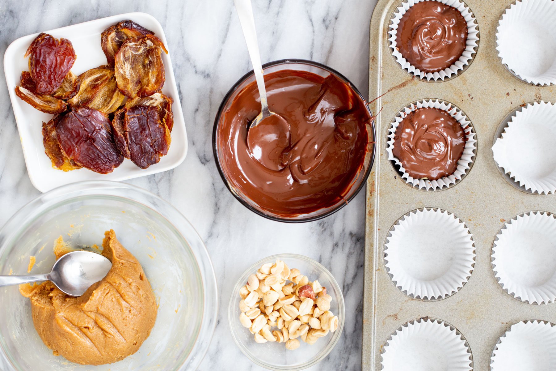melted chocolate being drizzled on top of peanut butter to make snickers cups