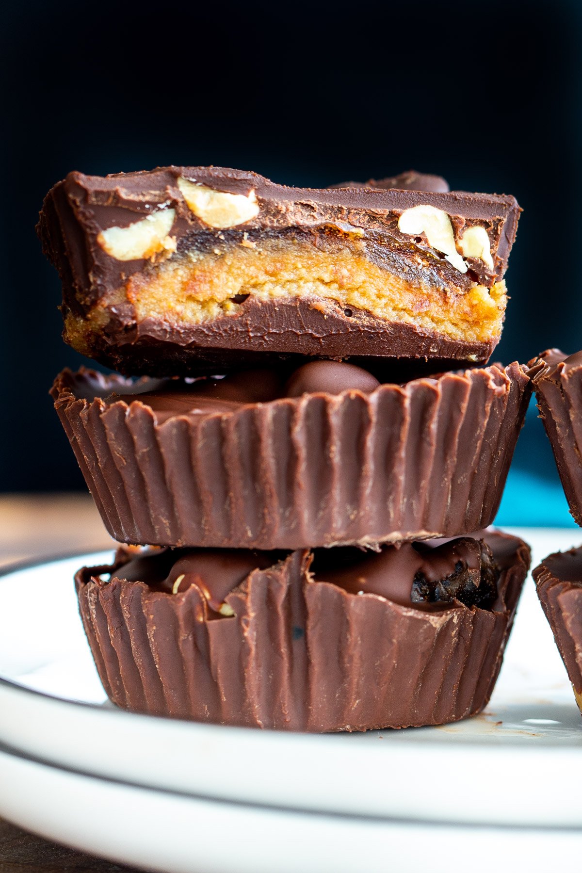 a stack of vegan snickers cups with dates on a white plate
