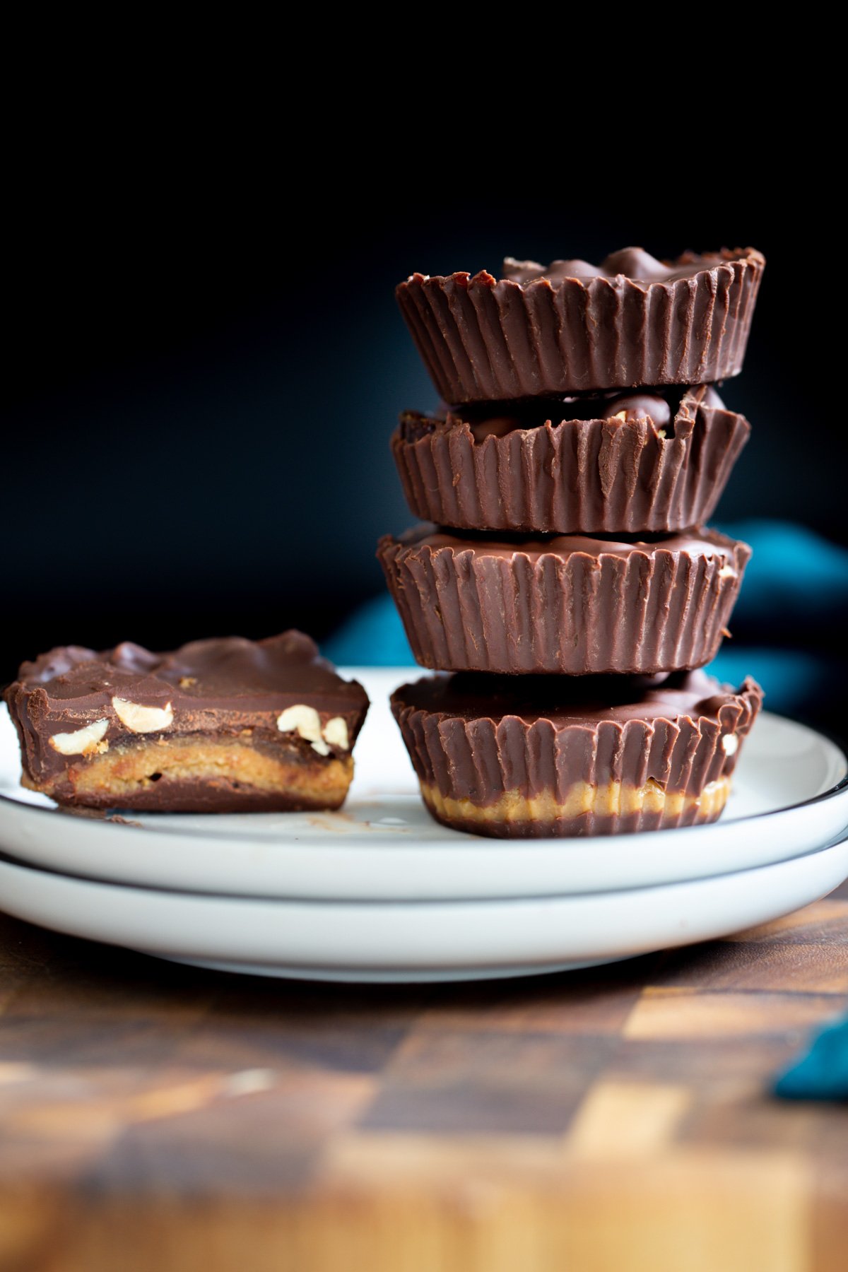 vegan snickers cups  vegan peanut butter snickers cups with dates against a black background