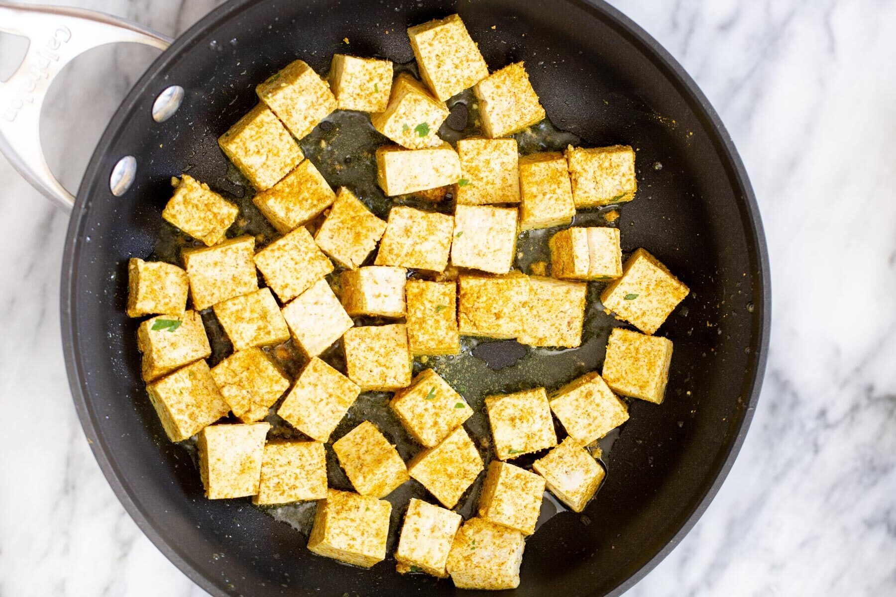 tofu malai  tofu cubes being fried in a sauteeing pan