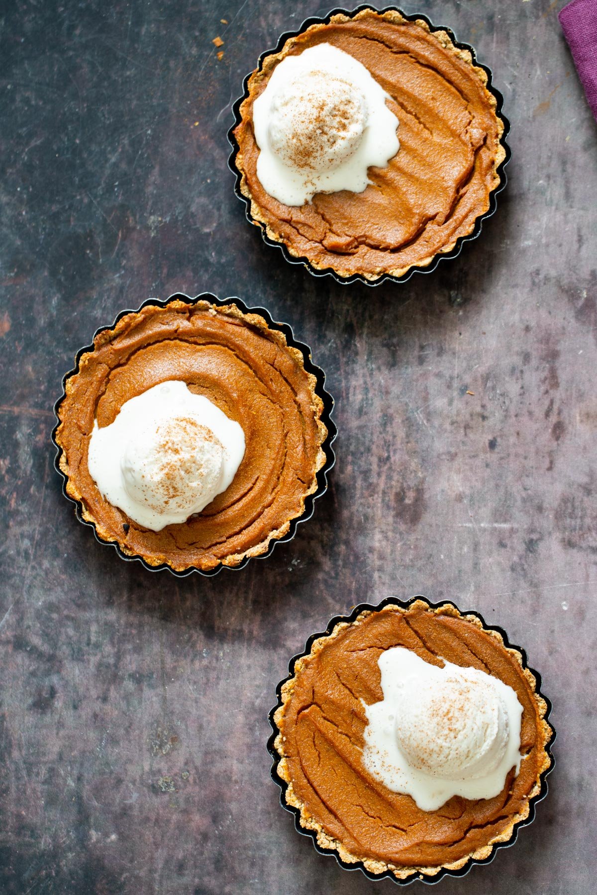 three individual gluten free vegan pumpkin pies with three scoops of ice cream
