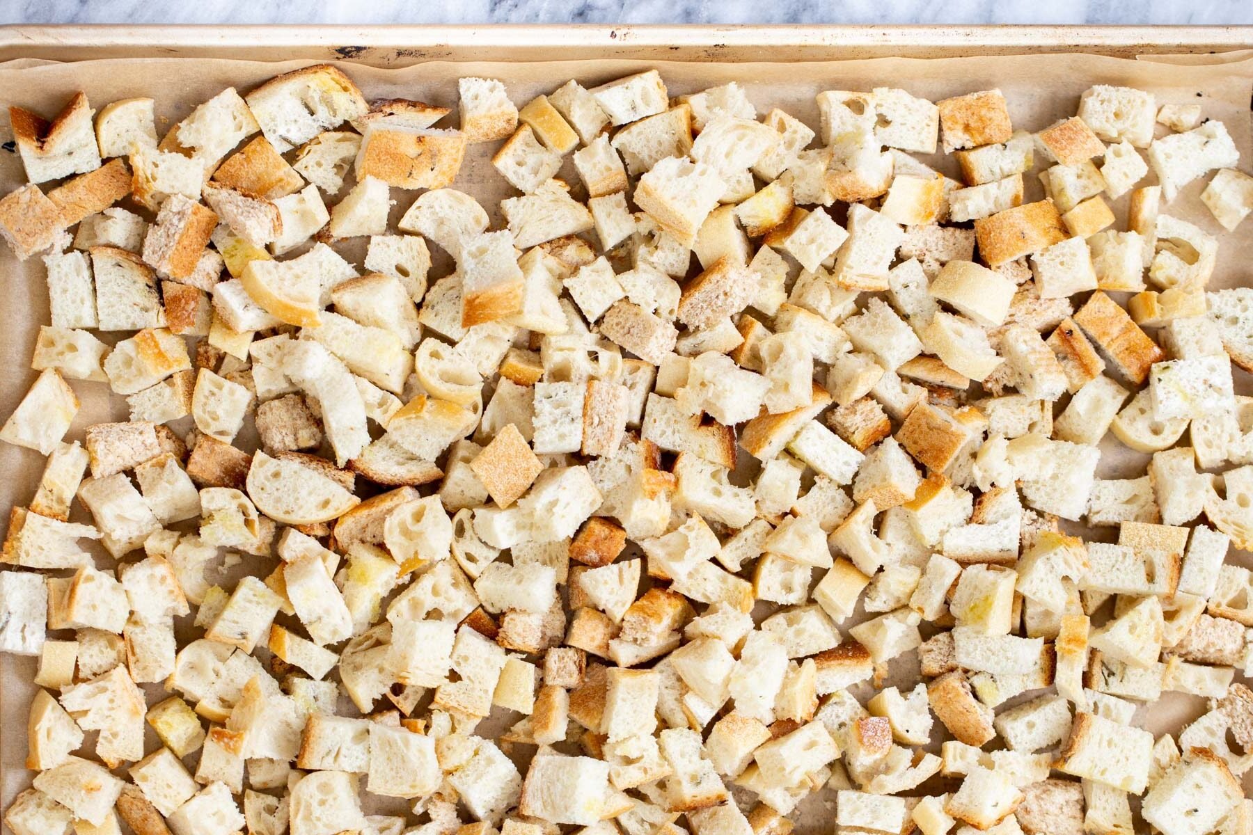 vegan stuffing vegan bread cubes on a lined baking sheet