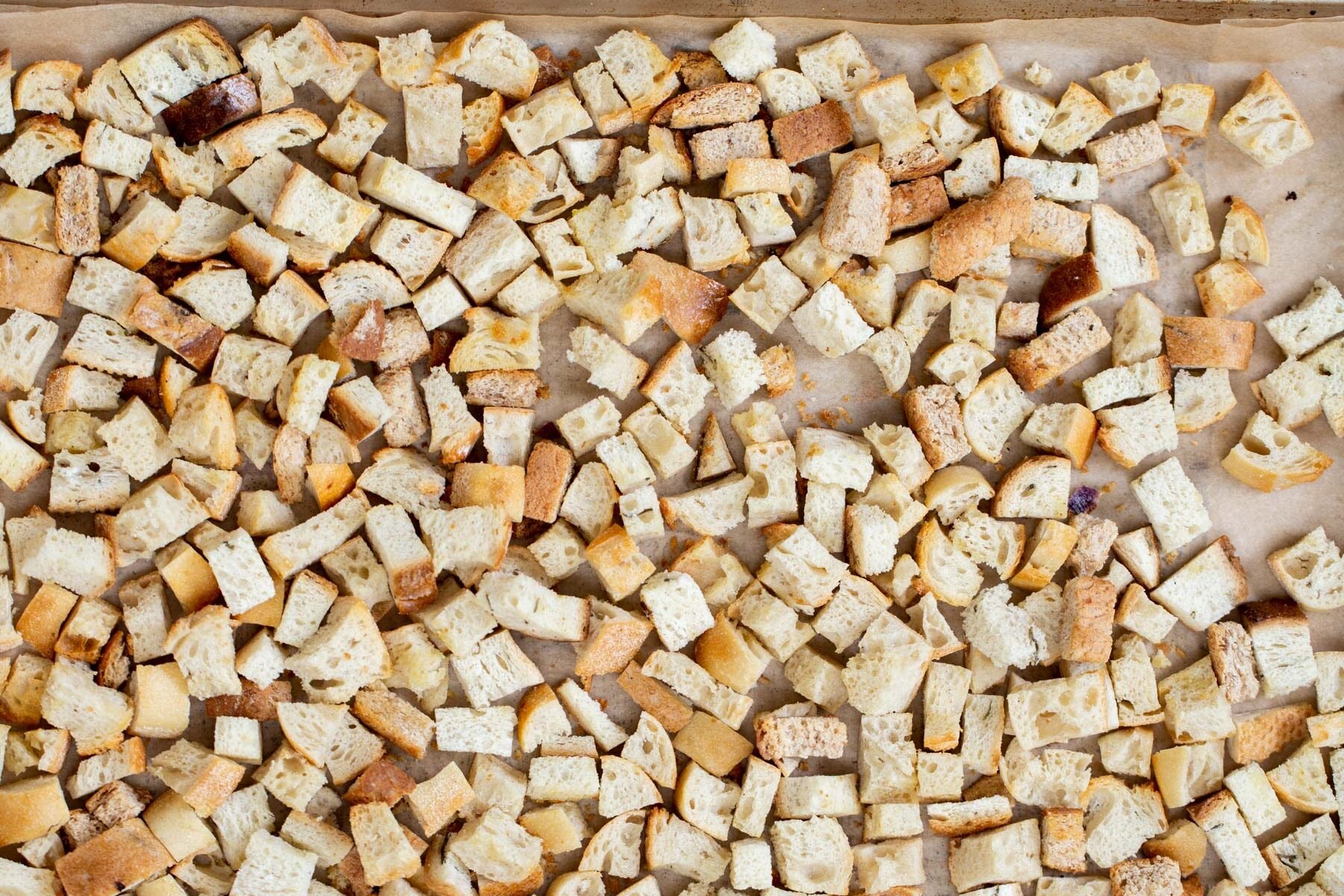 vegan stuffing  bread cubes toasting on a baking sheet